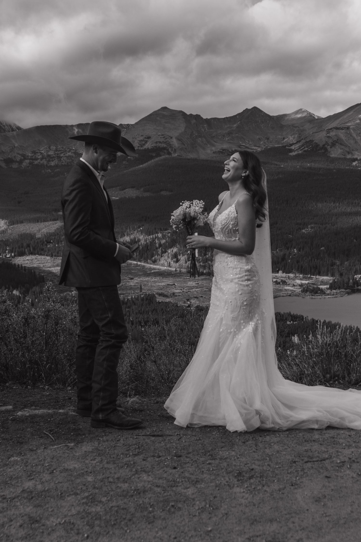 A black and white mountain wedding photo capturing a candid moment against dramatic peaks.