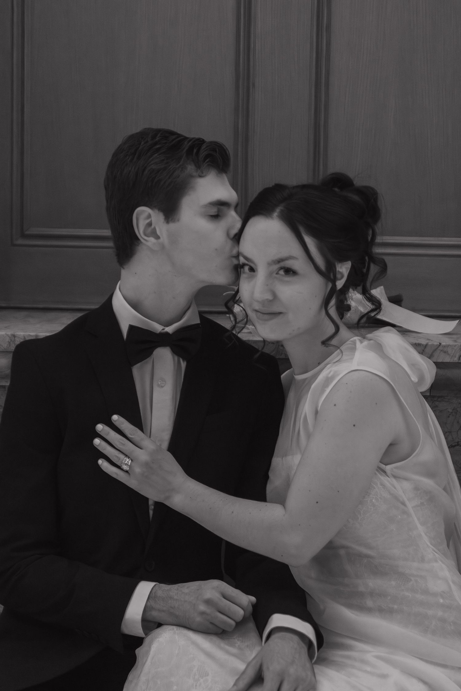 Intimate black and white portrait of a couple in formal attire.