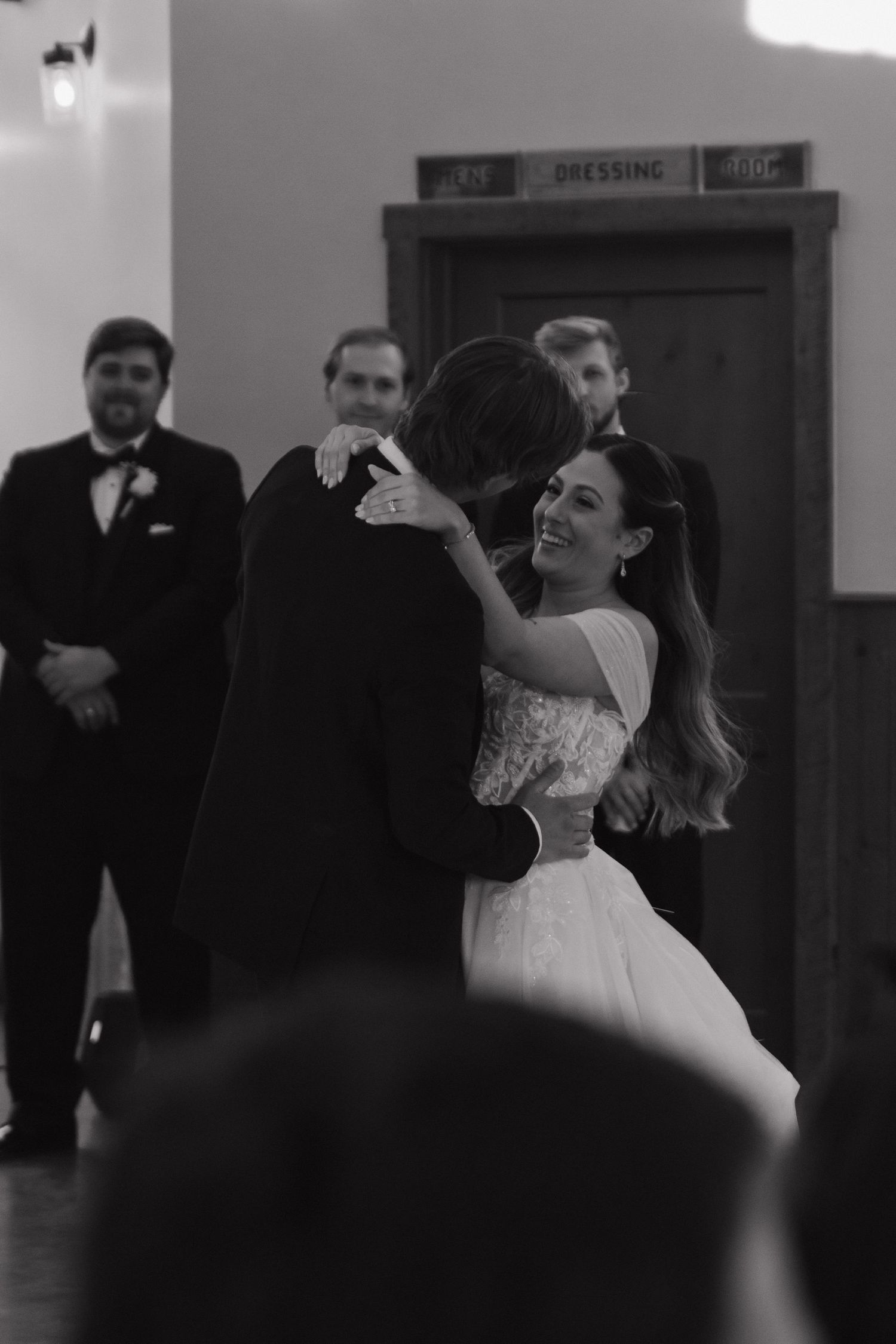 A wedding celebration in a dimly lit indoor venue with dancing and laughter.
