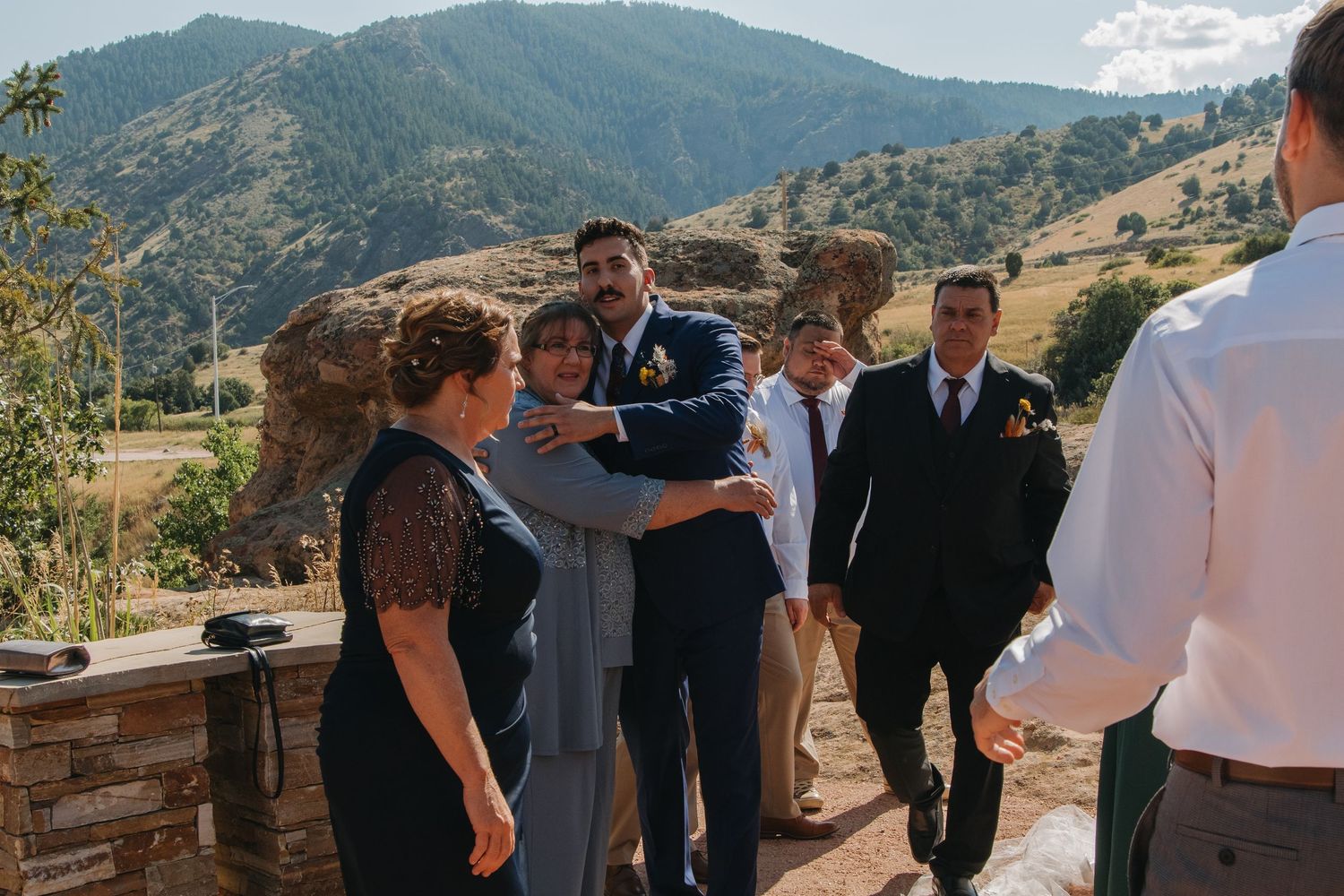 Wedding party members gathered on a scenic mountain overlook during celebration.
