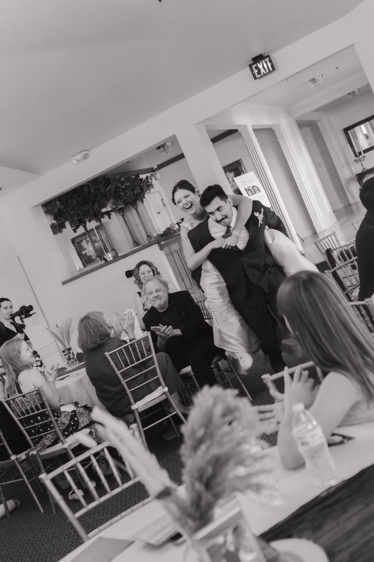 Wedding reception venue with guests mingling in a bright indoor setting.