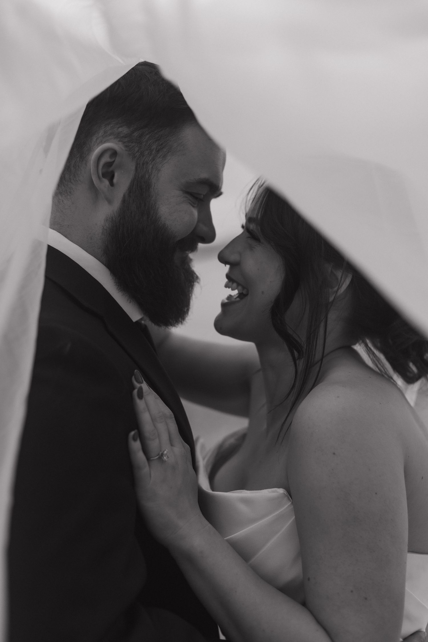 Romantic black and white wedding portrait of a couple in an intimate embrace.
