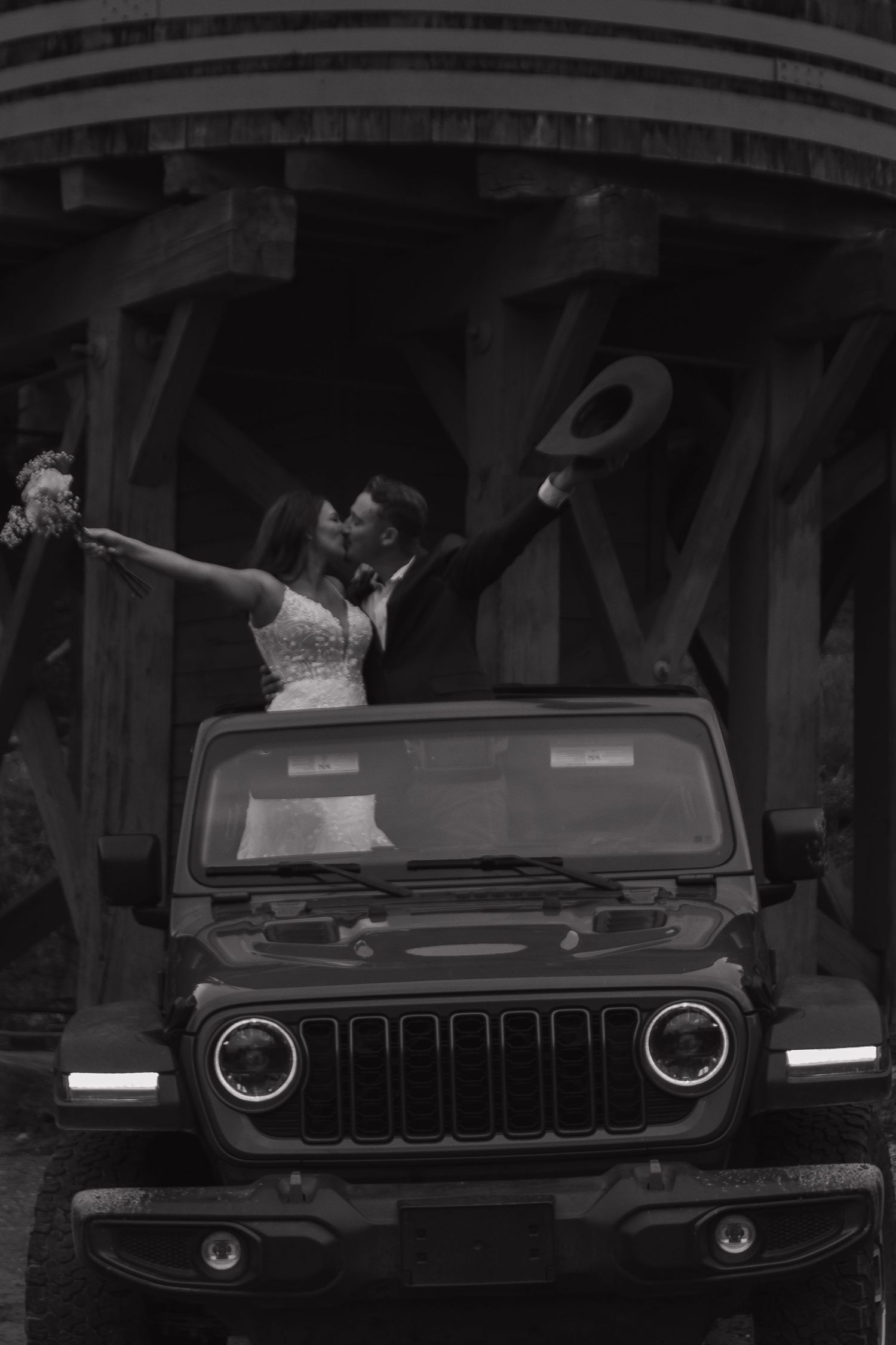A celebratory moment atop a black Jeep with a dramatic architectural backdrop.