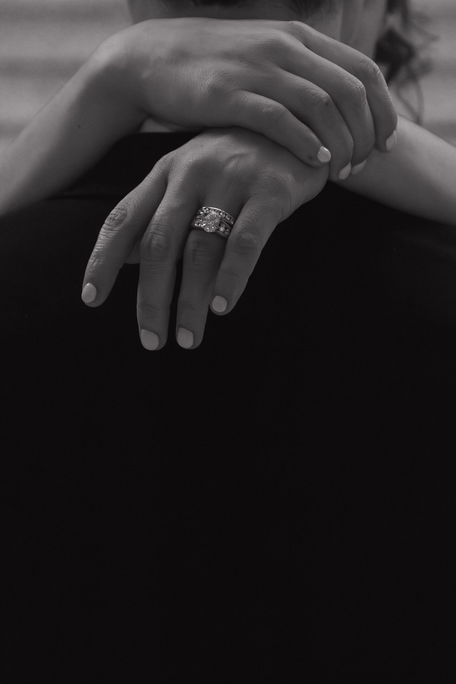 Close-up view of hands exchanging wedding rings during an intimate ceremony.