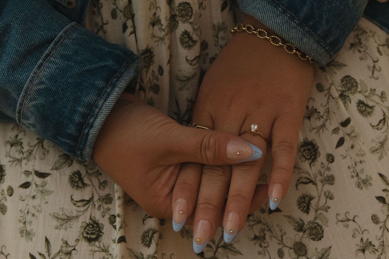 Close-up shots of hands with glittery silver nail polish and sparkly nail art designs against a floral background.