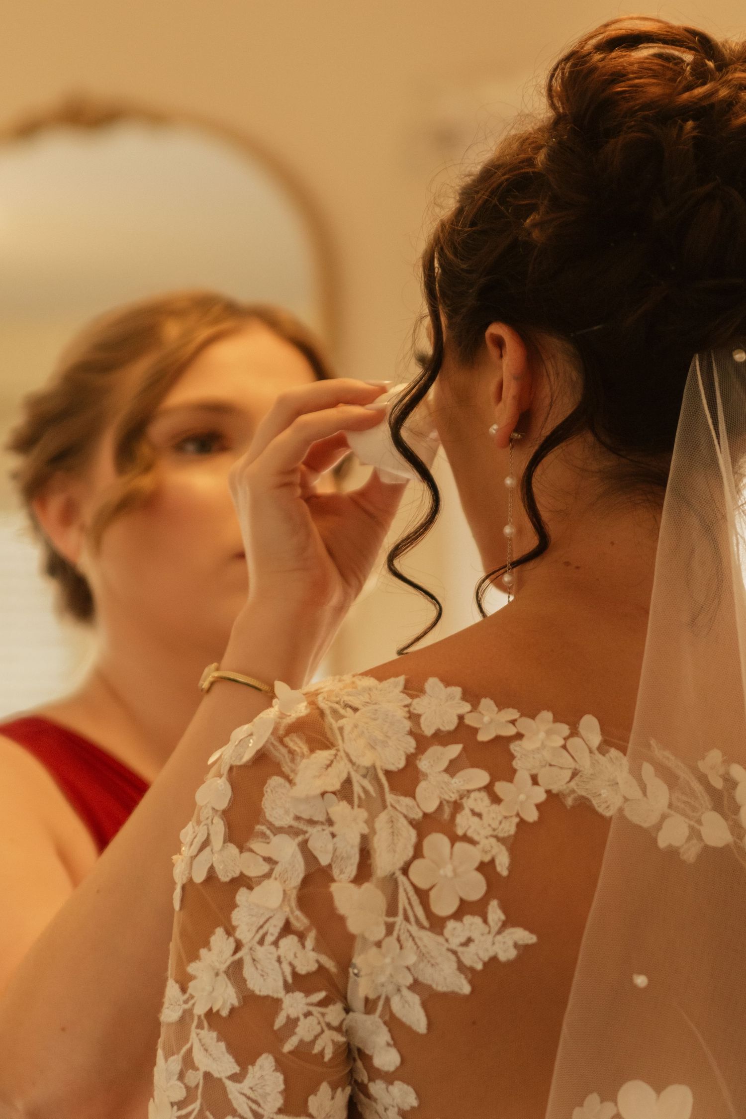Close-up detail of delicate floral lace on wedding veil and dress.
