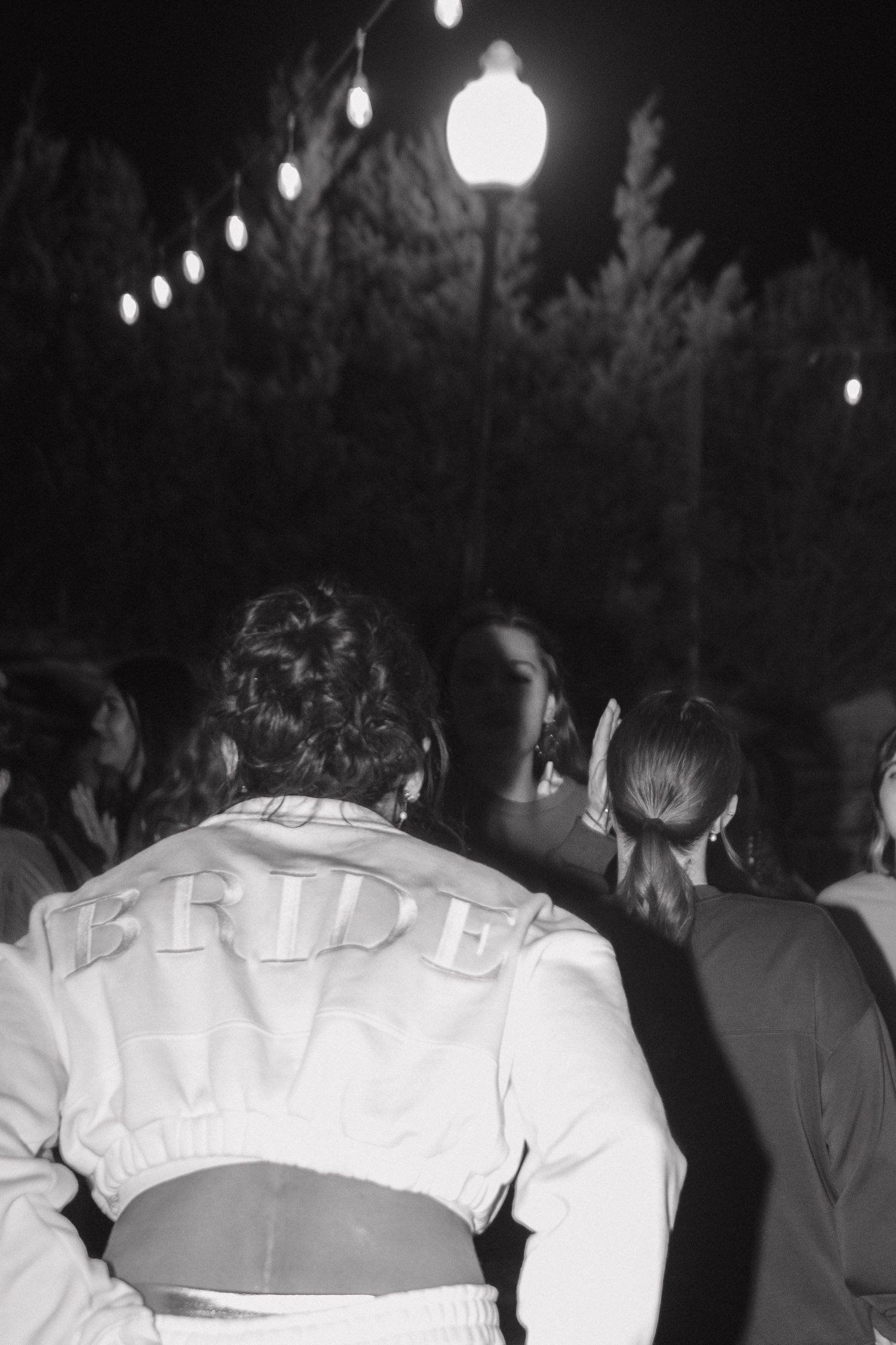 Black and white nighttime reception photo with string lights overhead.