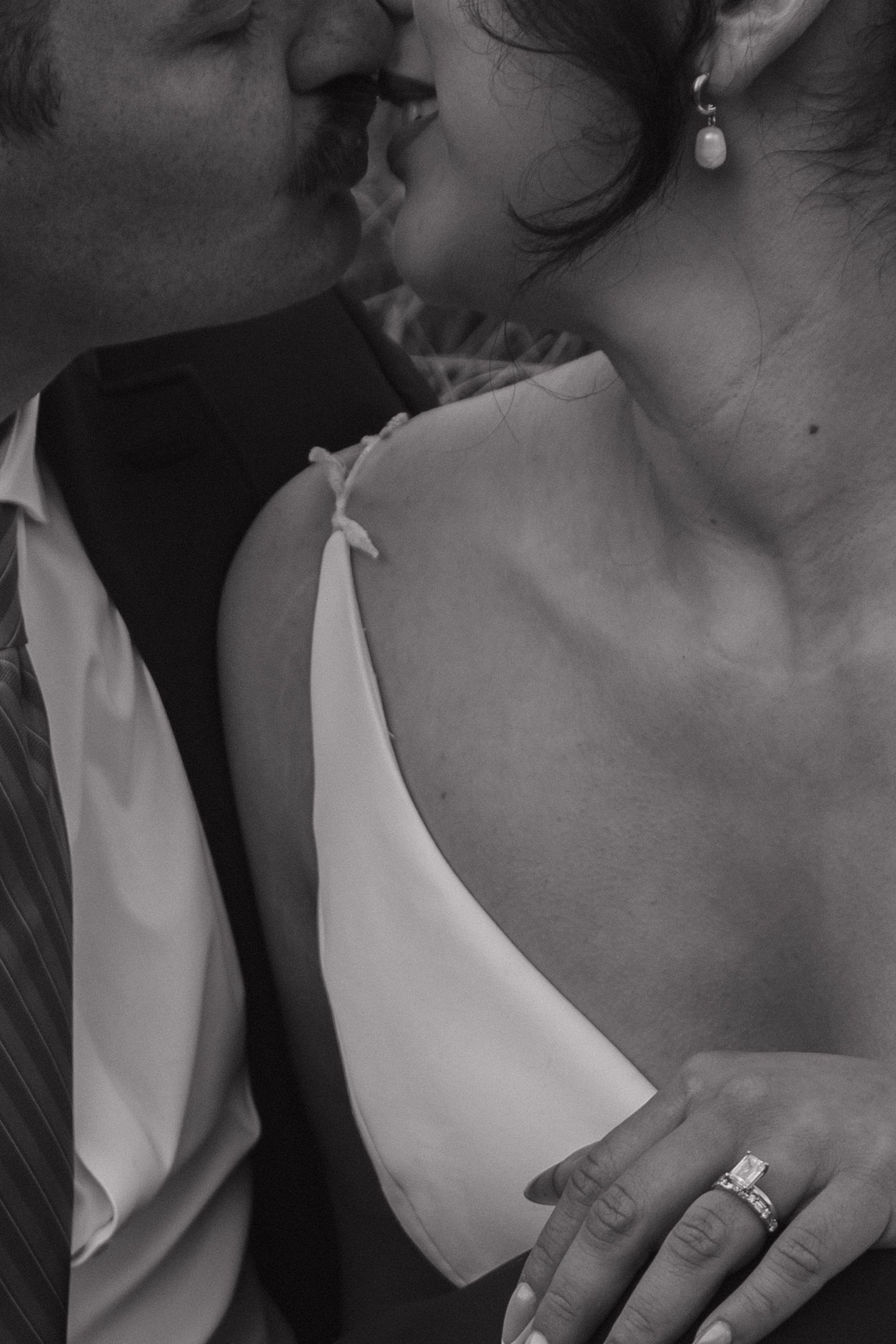 Black and white intimate portrait showing wedding rings and tender moments.