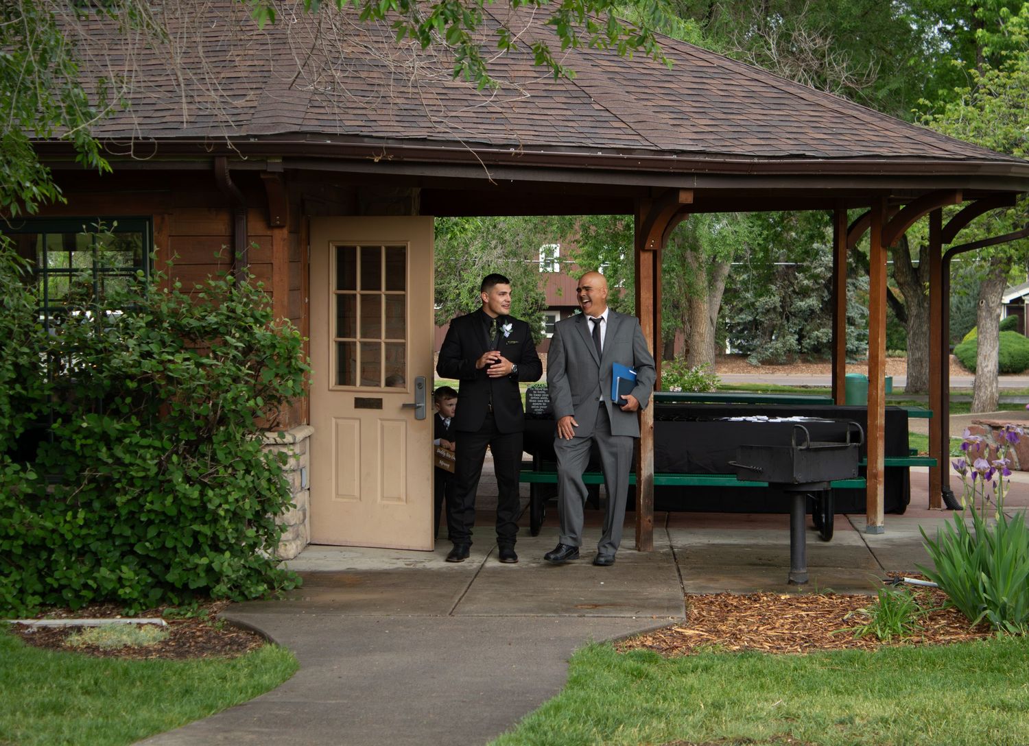 People in formal attire walking along covered pathway during wedding event.
