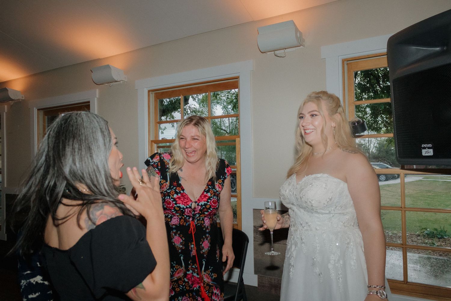 Wedding celebration in a bright room with large windows and natural lighting.