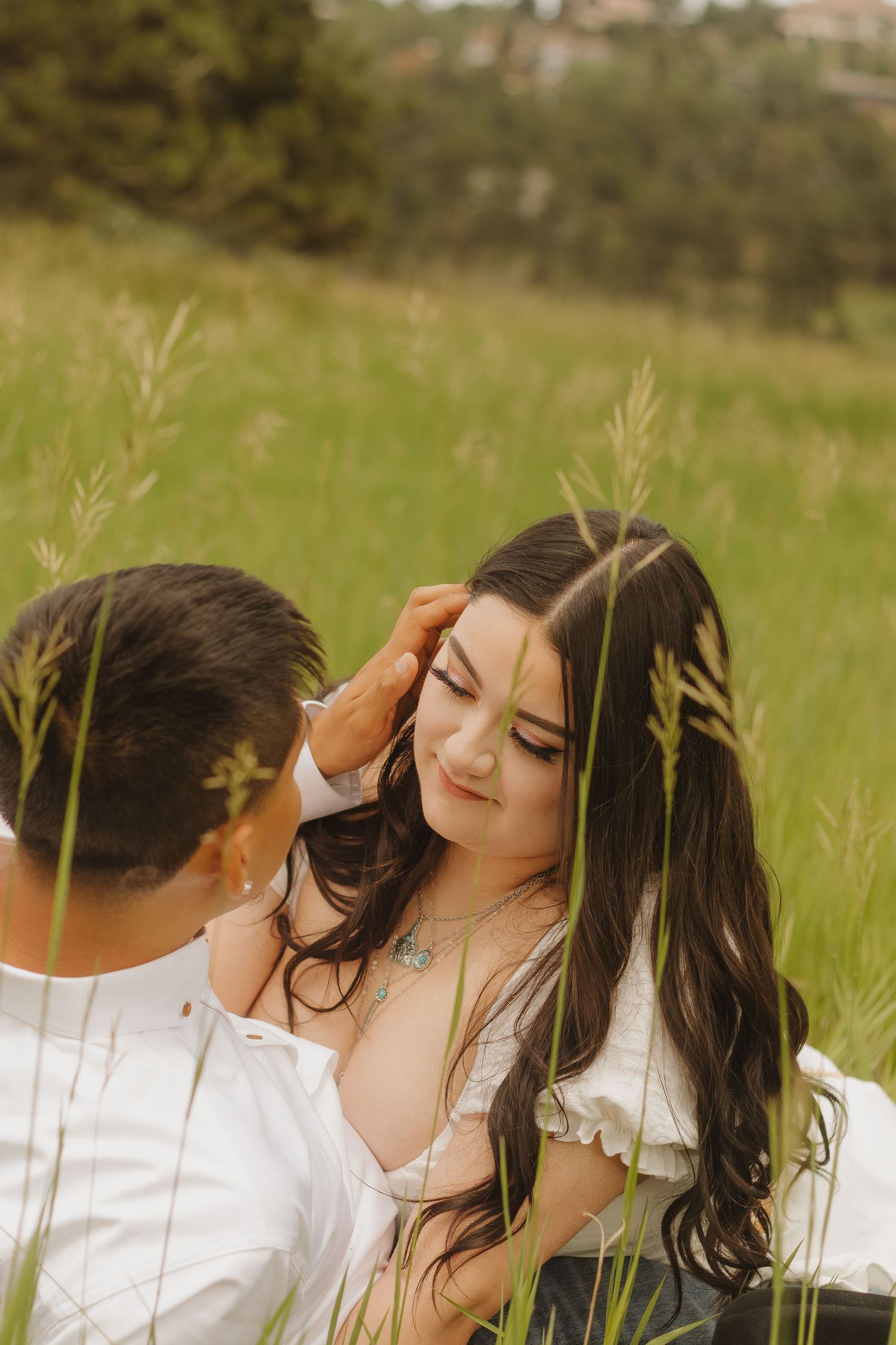 A tender moment captured between two people in a golden grass field.