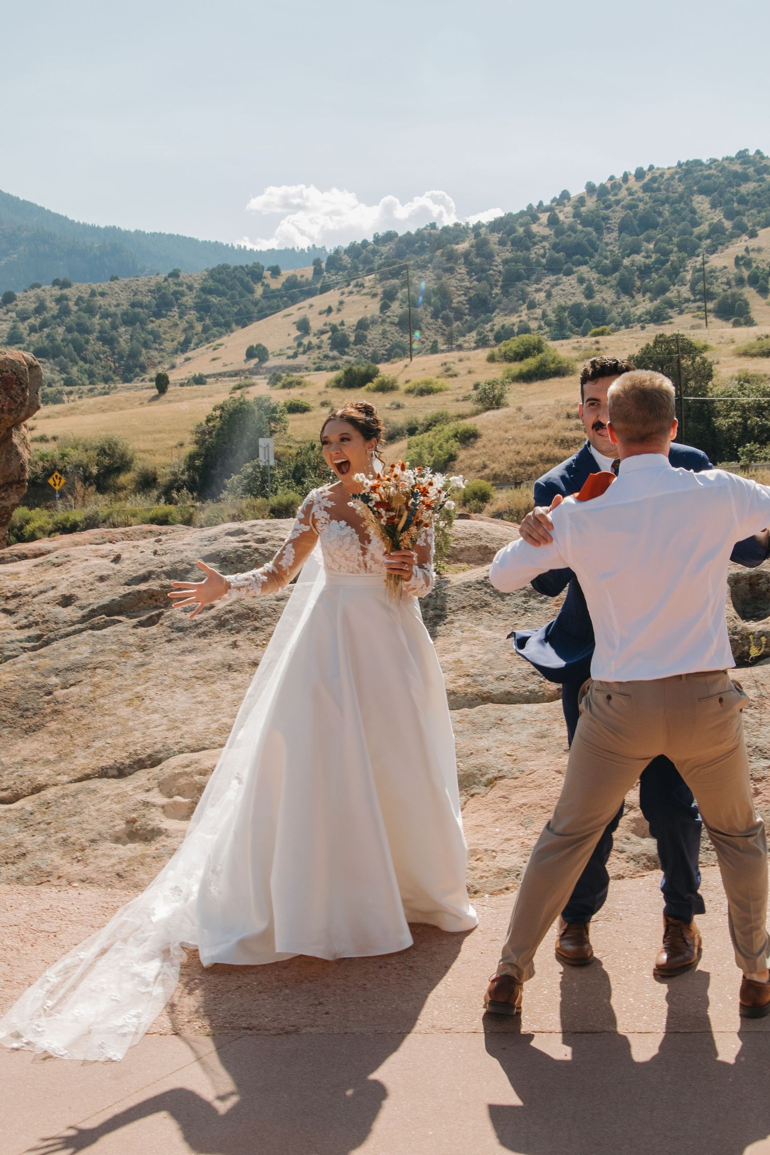 Wedding photo shoot on a scenic mountain overlook with dramatic landscape views.