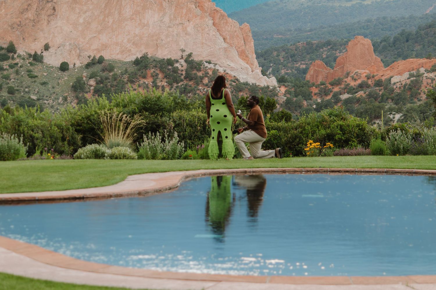 Garden of the Gods park in Colorado Springs features stunning red rock formations against a blue sky and mountain backdrop.