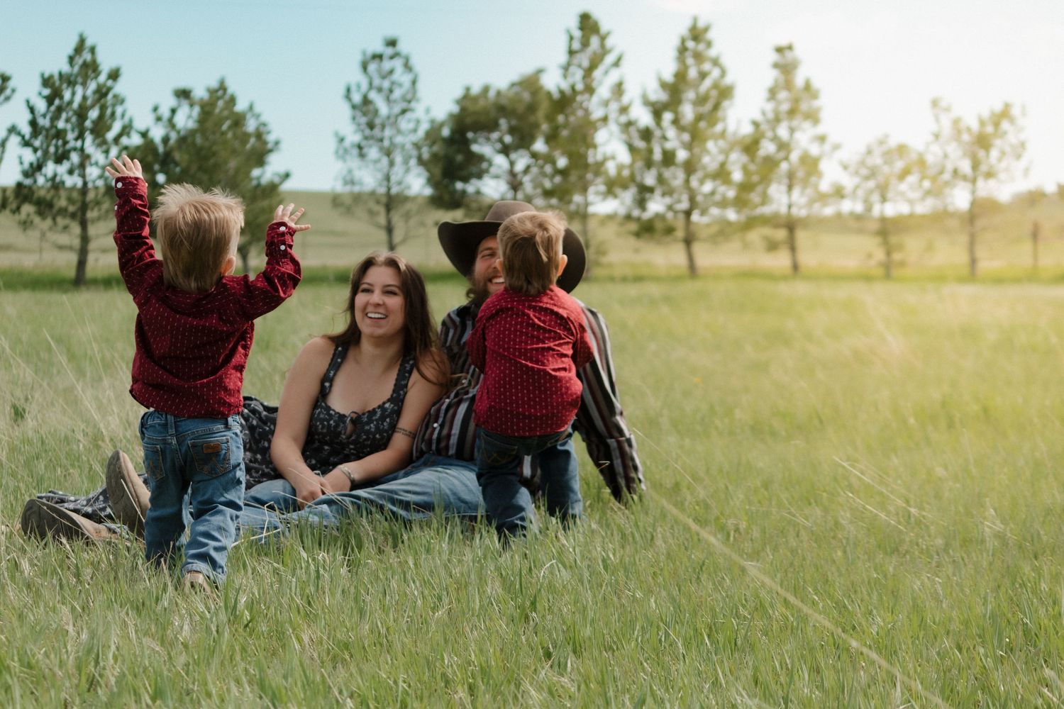 A casual outdoor gathering in a grassy field with sunset lighting.