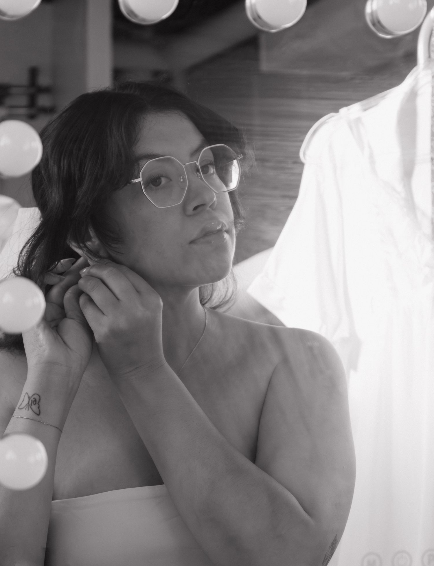 Getting ready scene with vanity lights reflecting in mirror during wedding preparation.