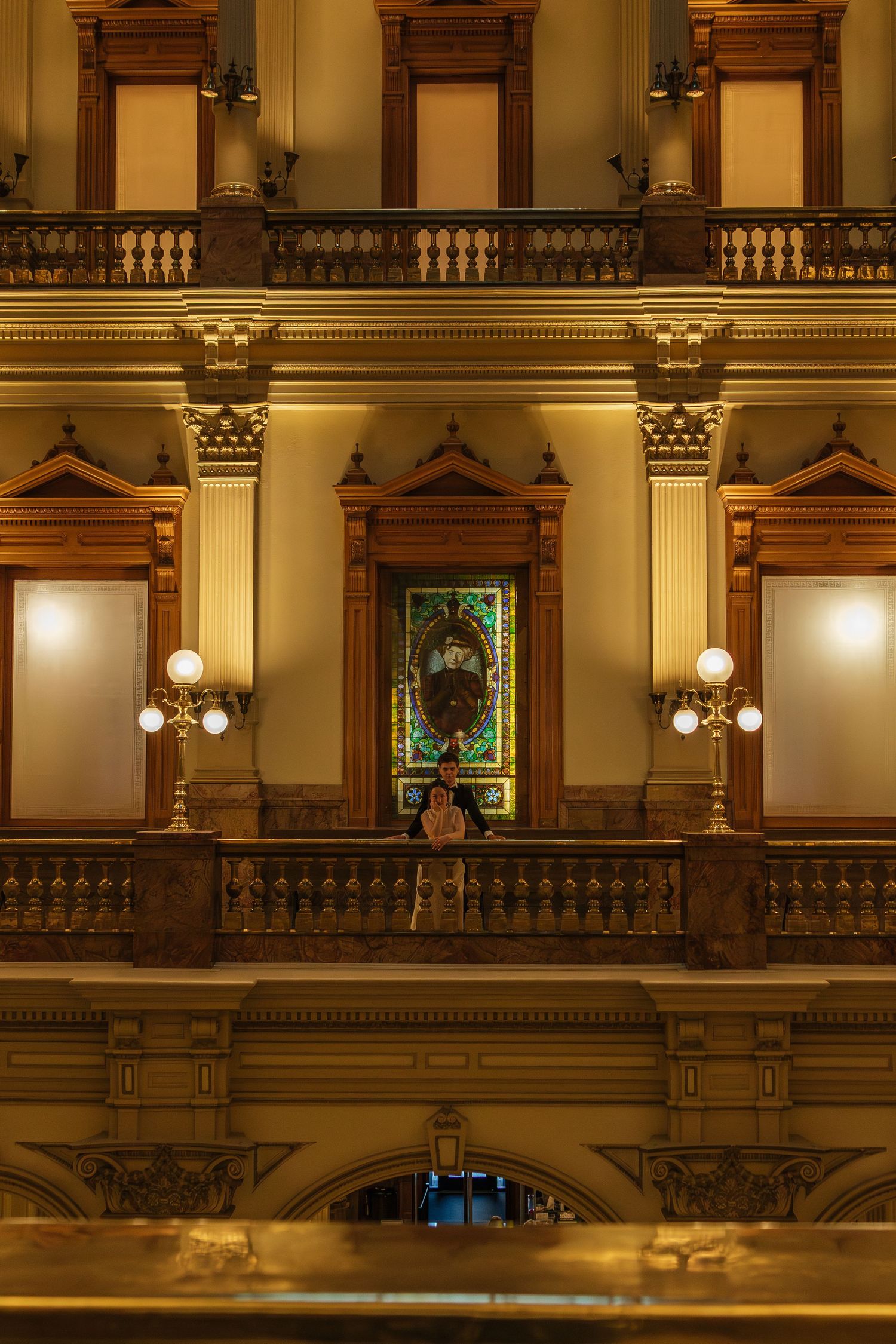 Ornate architectural details of a historic building interior with golden lighting and decorative balustrades.