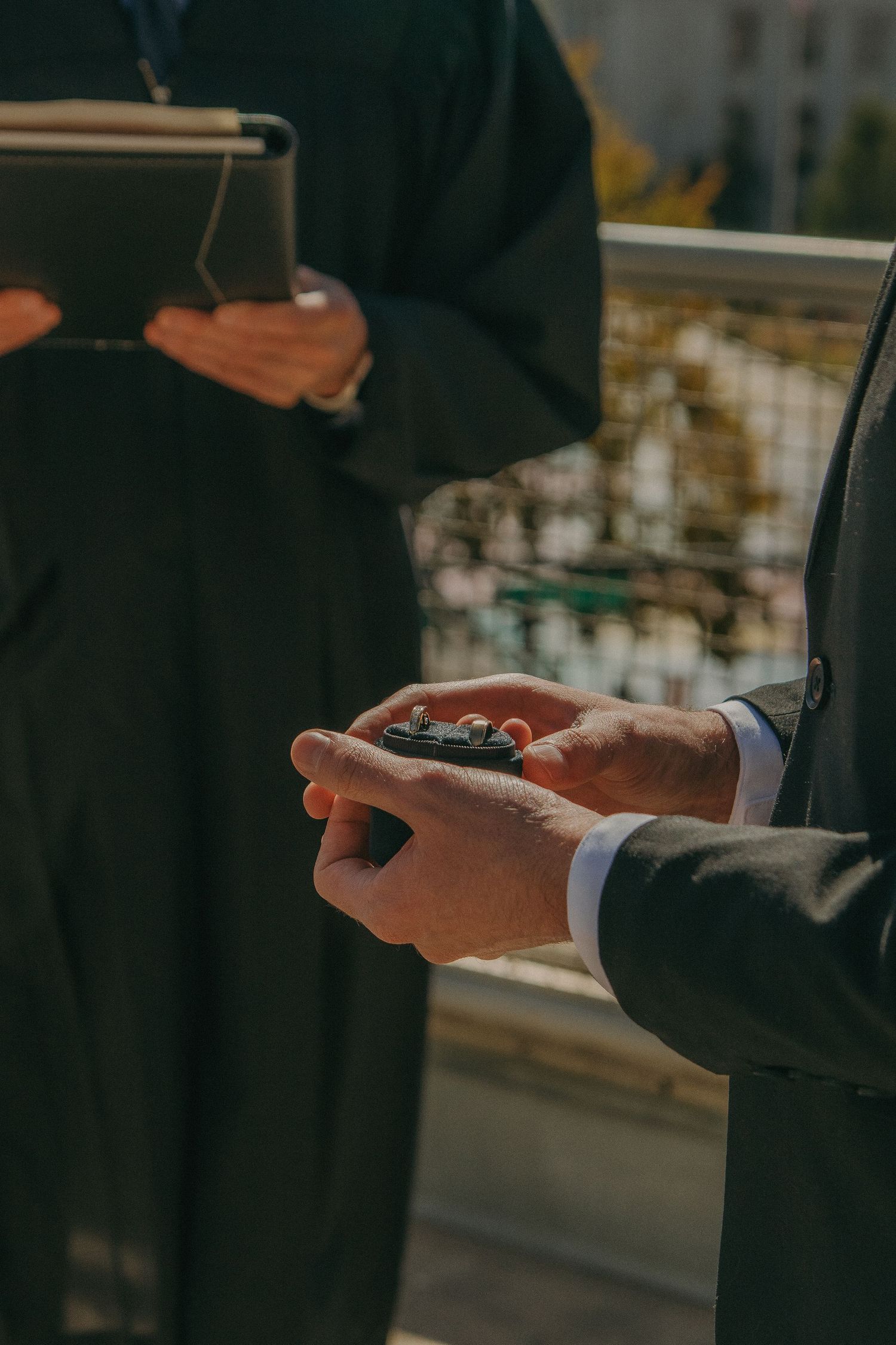 Close-up of hands exchanging rings during a wedding ceremony.