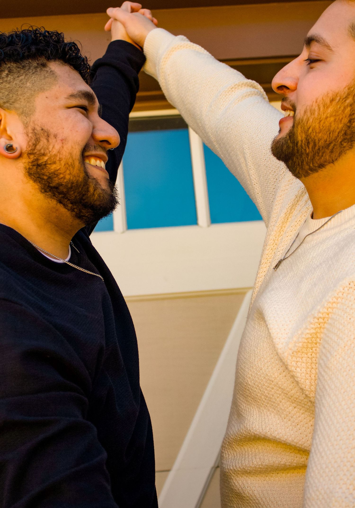 Two people sharing joyful dance moment indoors with natural lighting.