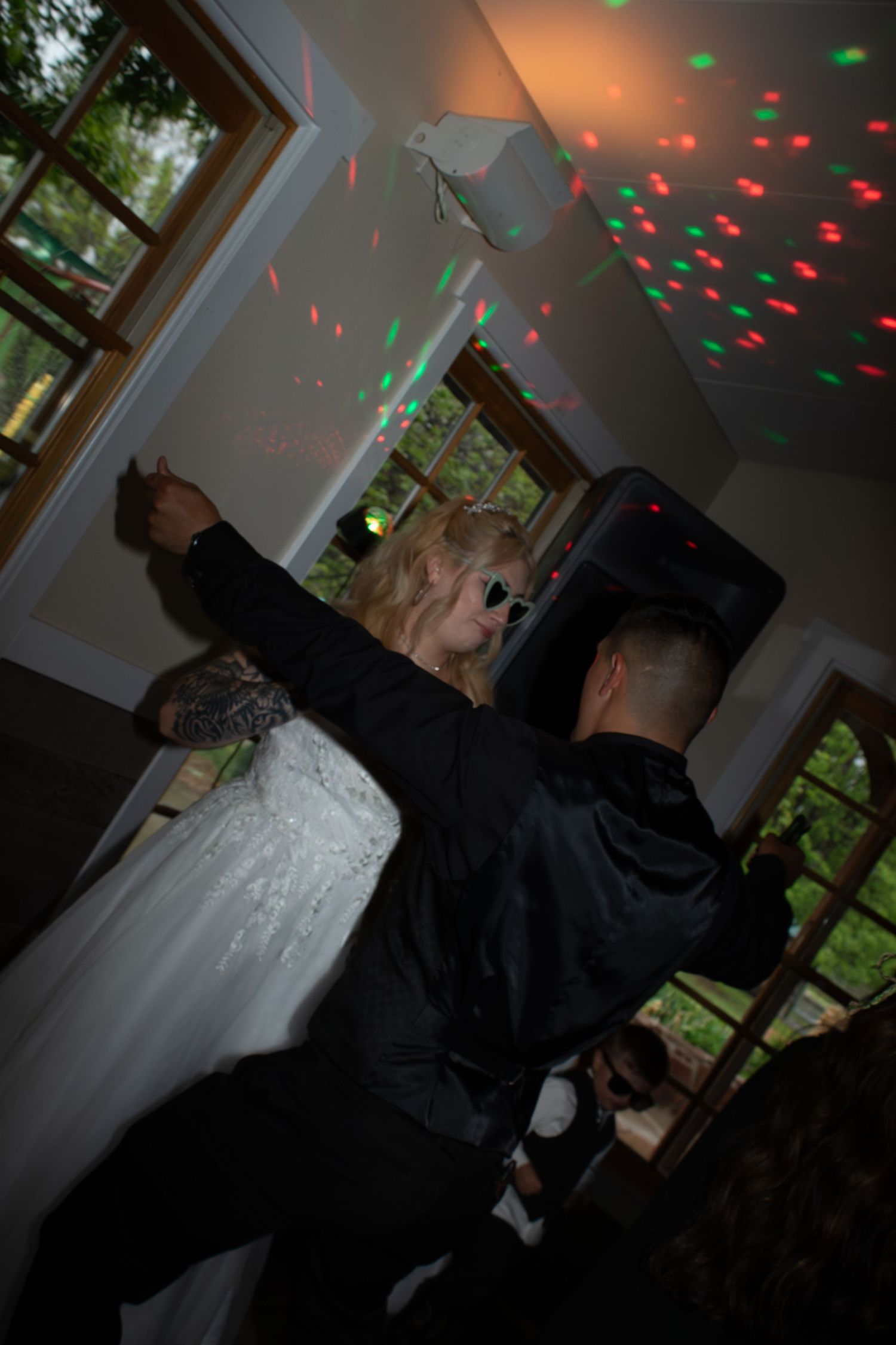 Party scene with disco lights creating red and green patterns on white walls and ceiling.