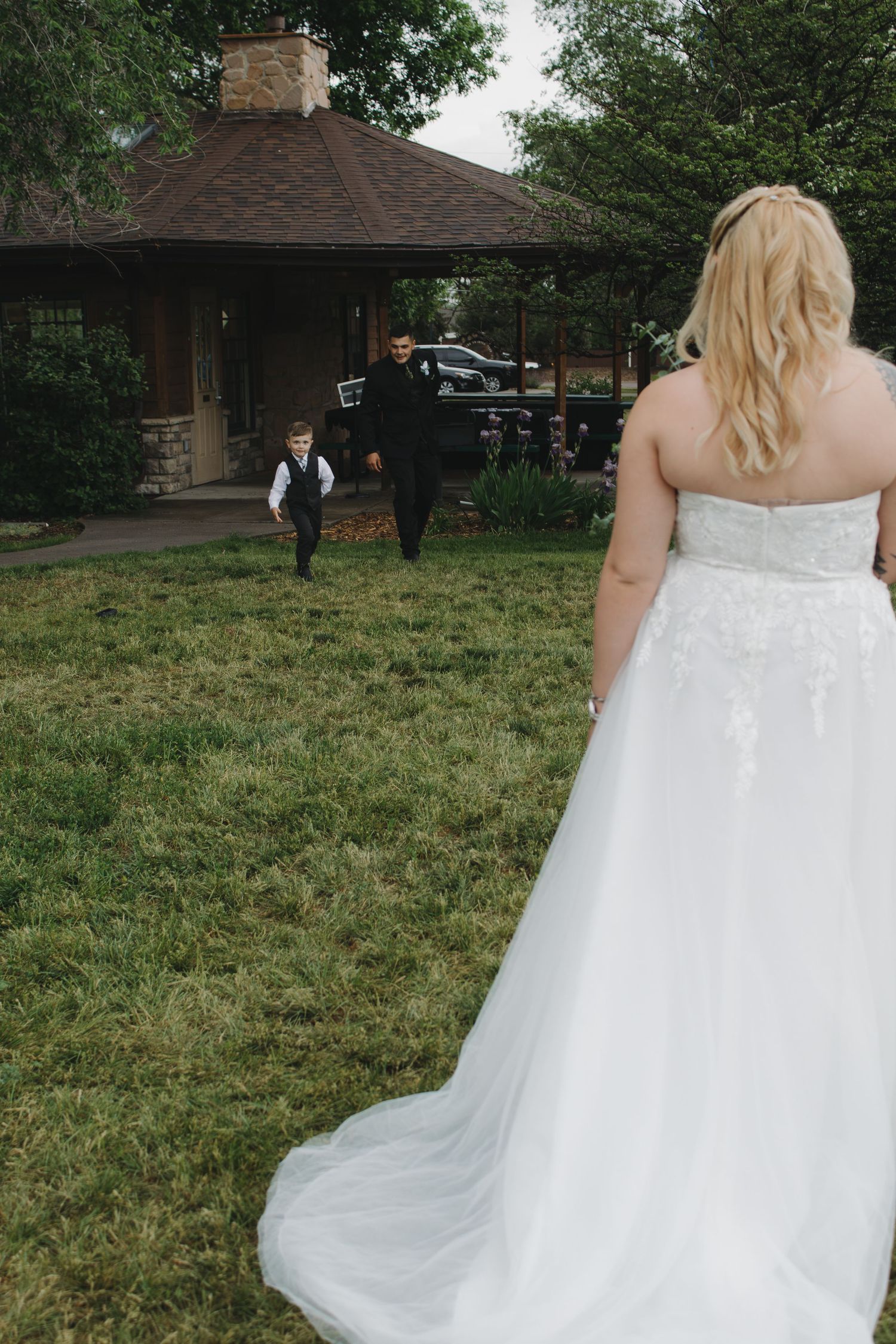 An outdoor wedding scene featuring a flowing white dress against a grassy landscape.