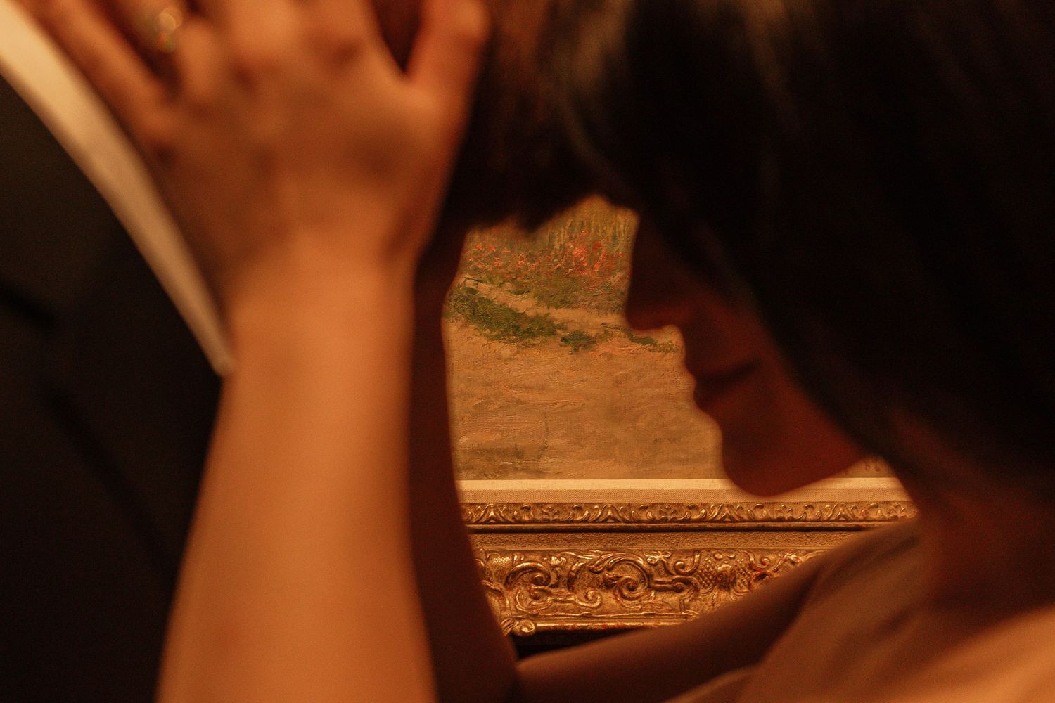 Close-up detail of an intimate moment between two people against a warm-toned background.