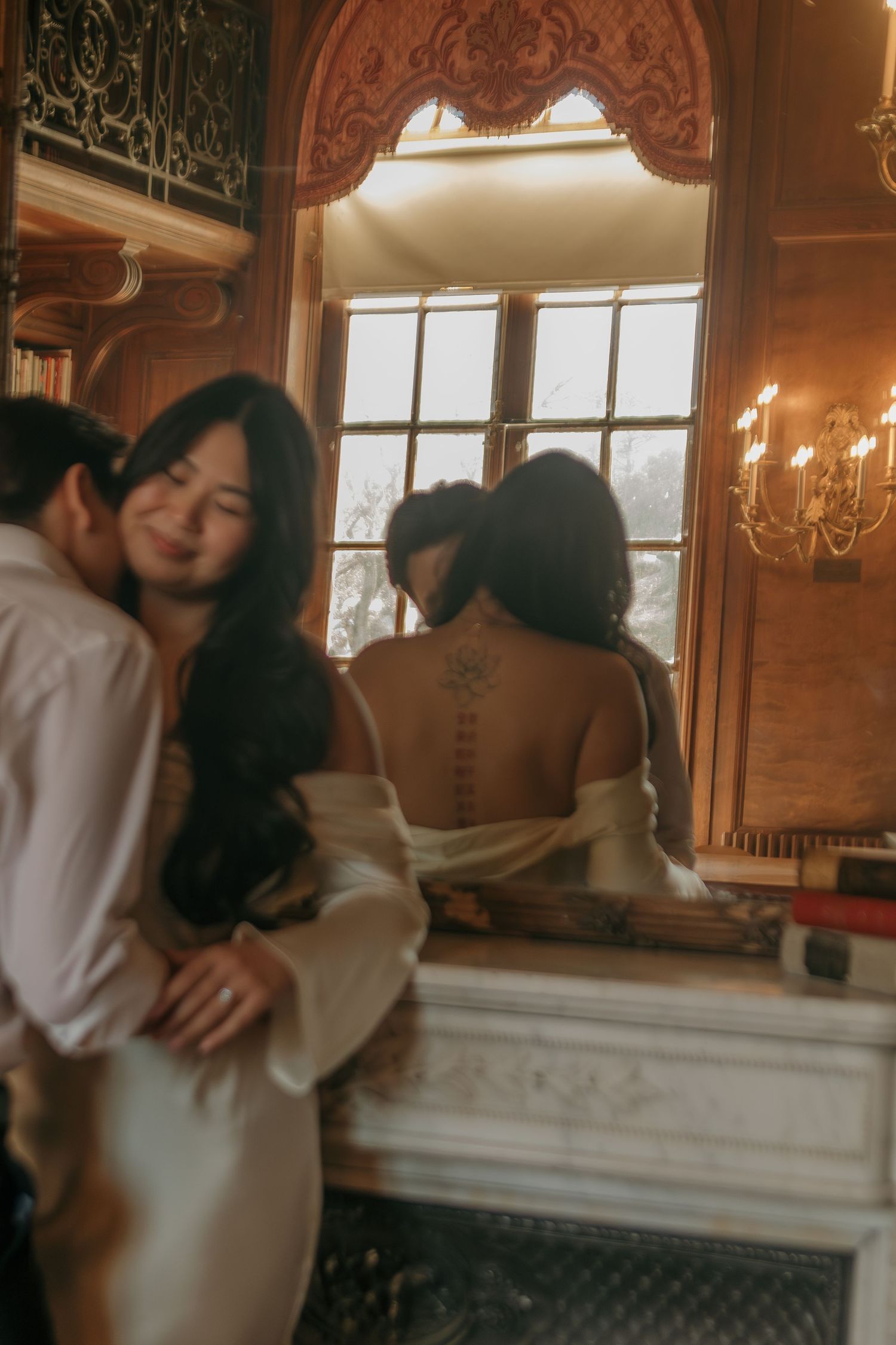 Romantic couple embracing in an elegant room with ornate decor and warm lighting.
