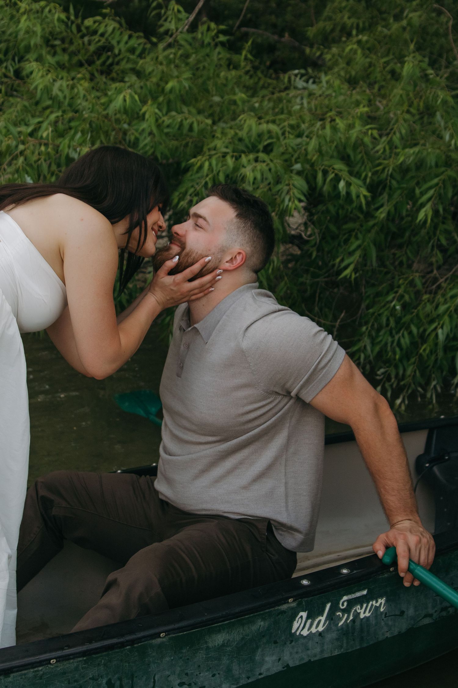 A couple shares affectionate moments while relaxing in an old wooden boat.