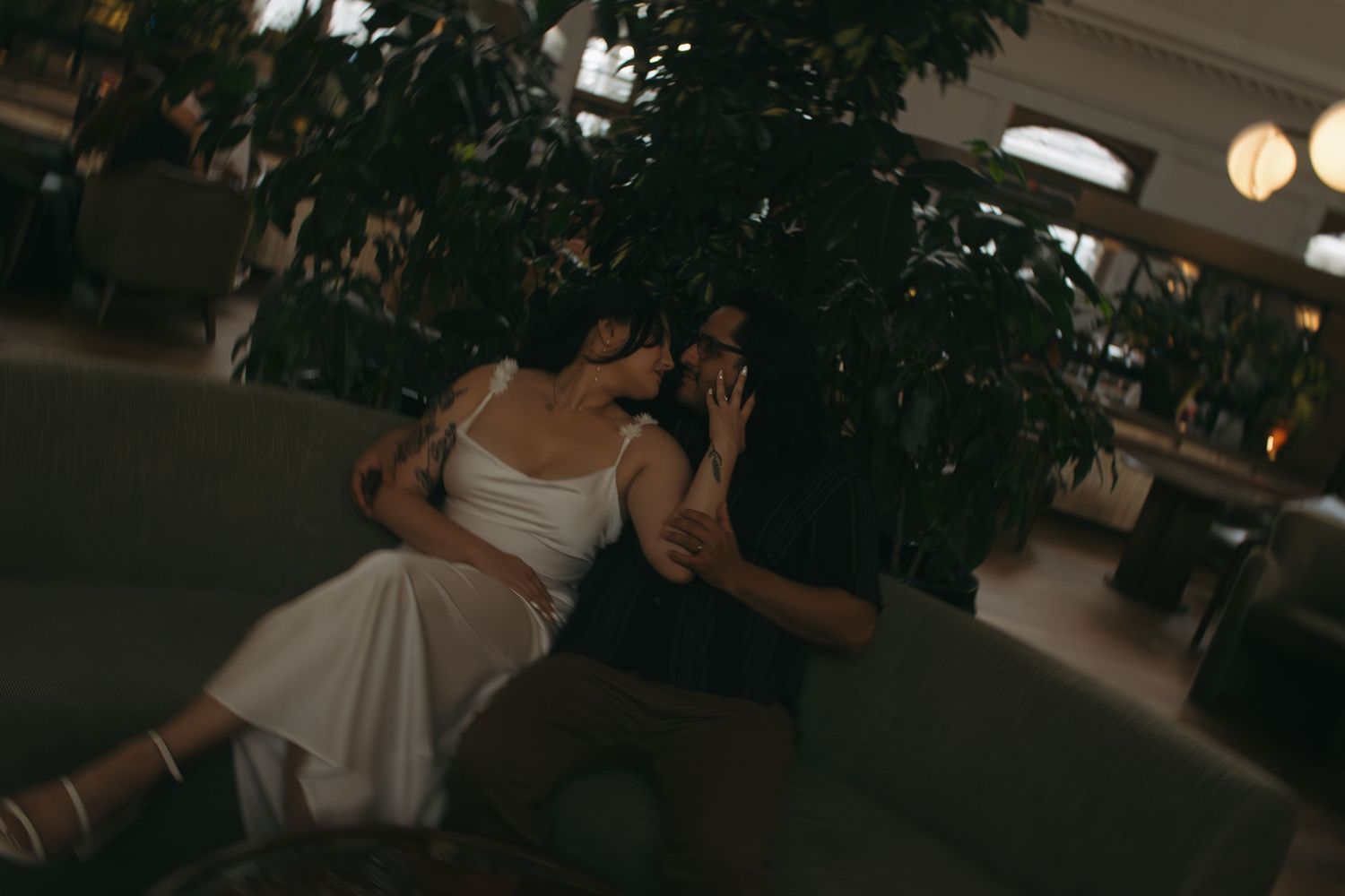 Couples mingling at a social gathering under soft mood lighting in an elegant venue.
