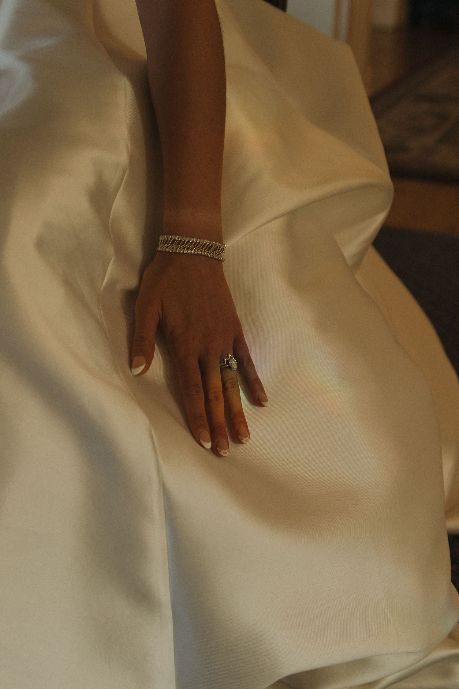 Close-up details of a white wedding dress fabric and accessories.