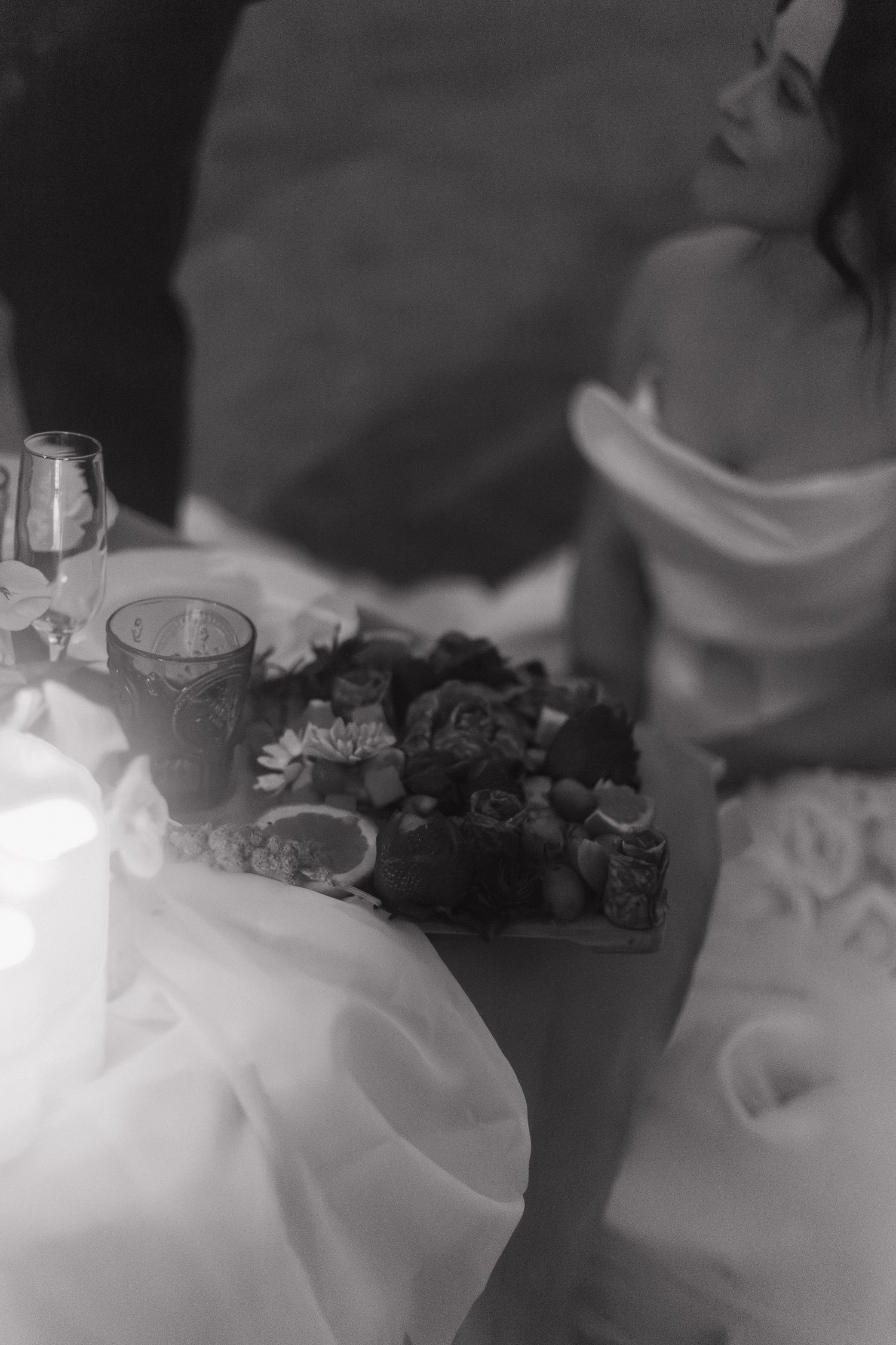 A wedding reception table setting with wine glasses and candles in black and white.