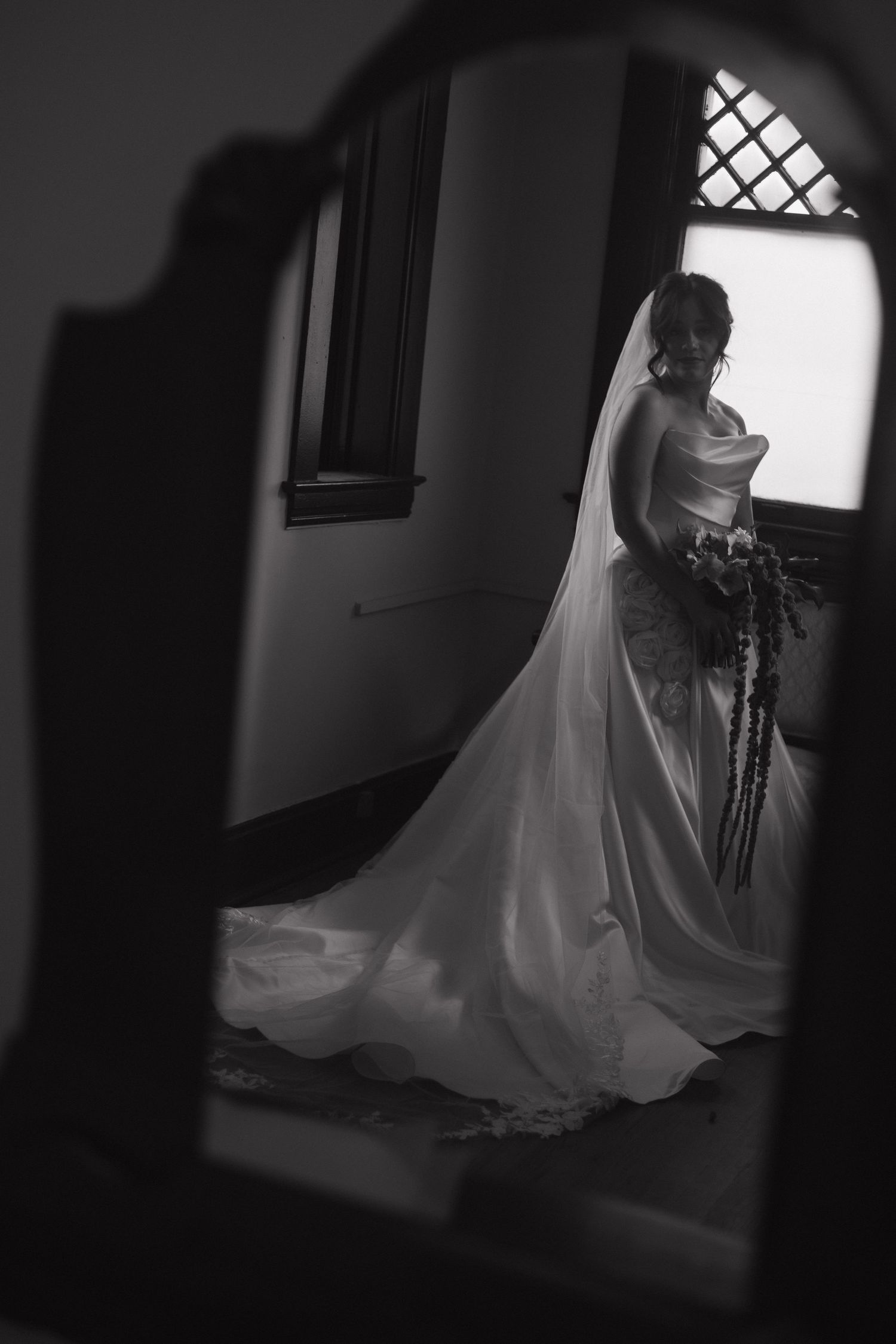 Black and white photos of a bride in a flowing wedding dress moving through a dimly lit room.