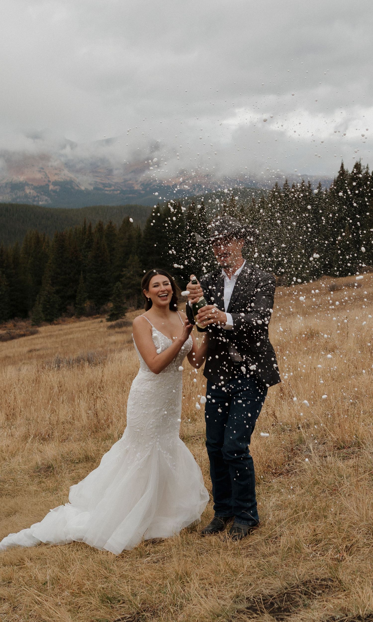 A celebratory moment with champagne spray against a misty mountain backdrop.