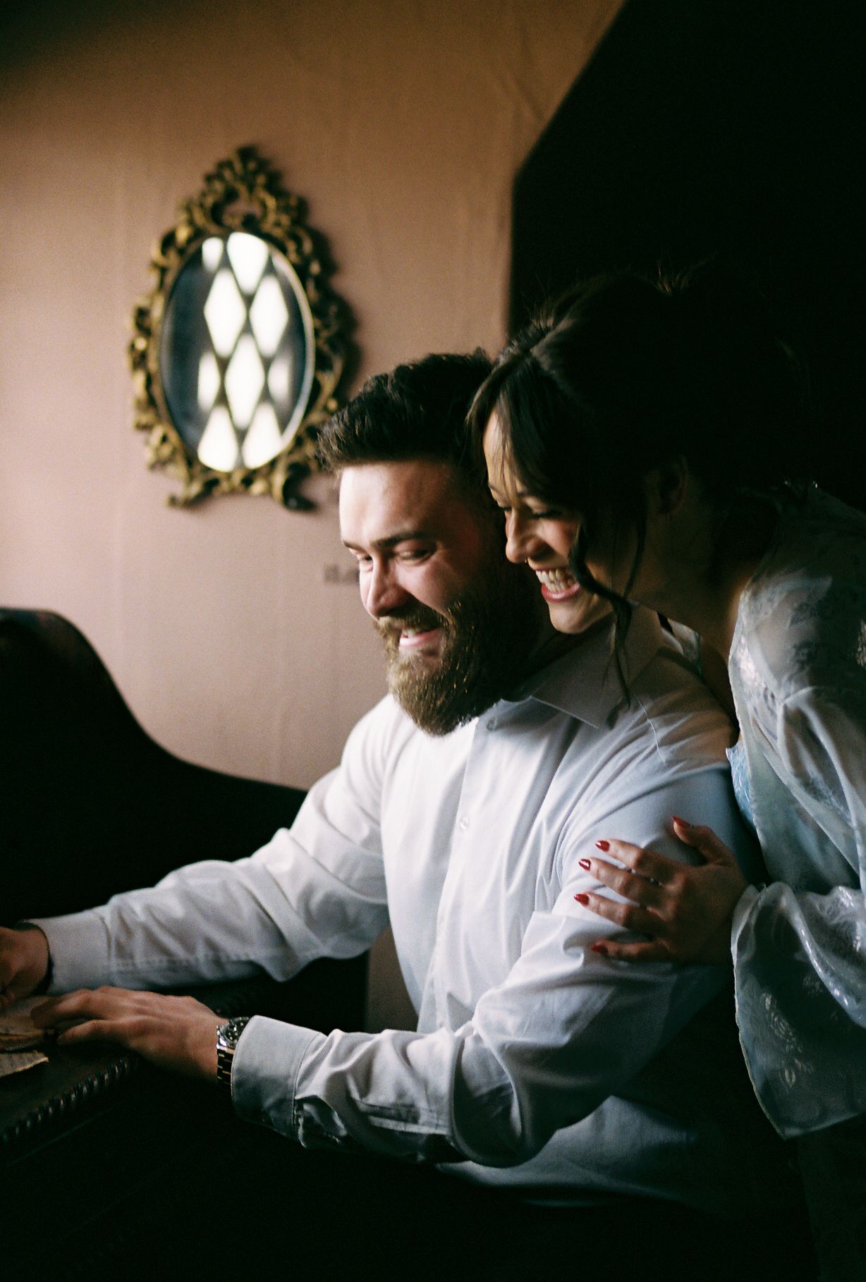 Two chefs in white uniforms work together in a dimly lit kitchen space, focusing on their culinary tasks.