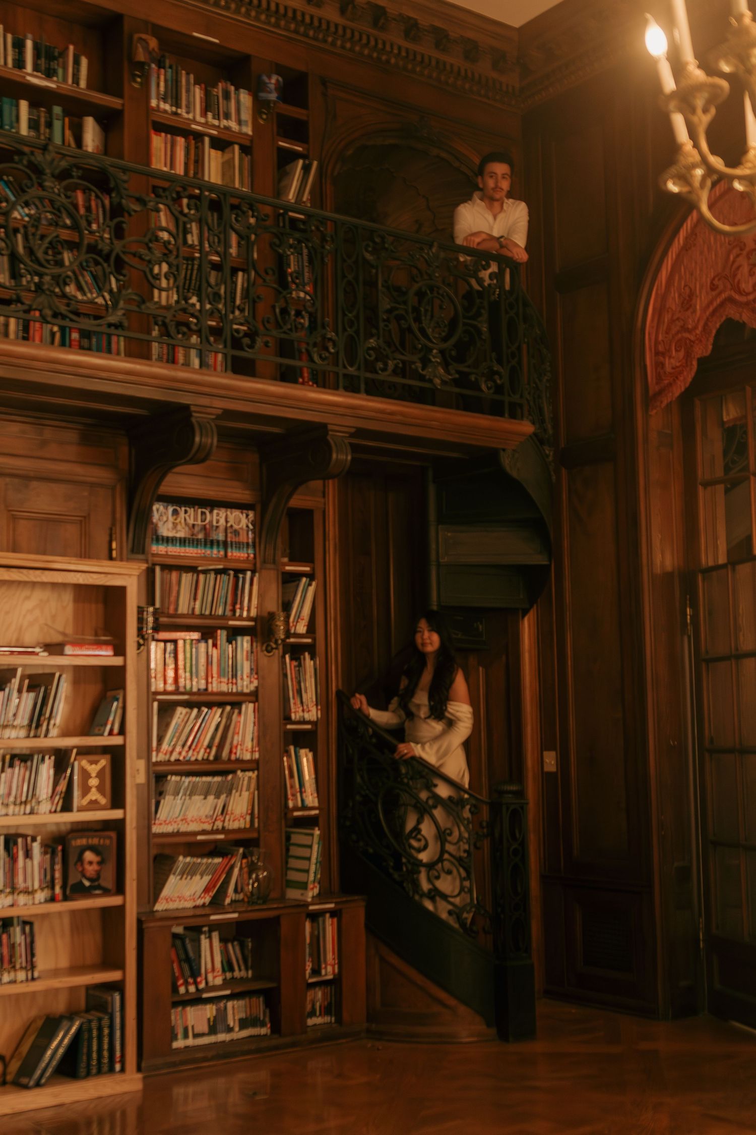 Ornate vintage library interior with wooden bookshelves and decorative moldings in warm lighting.