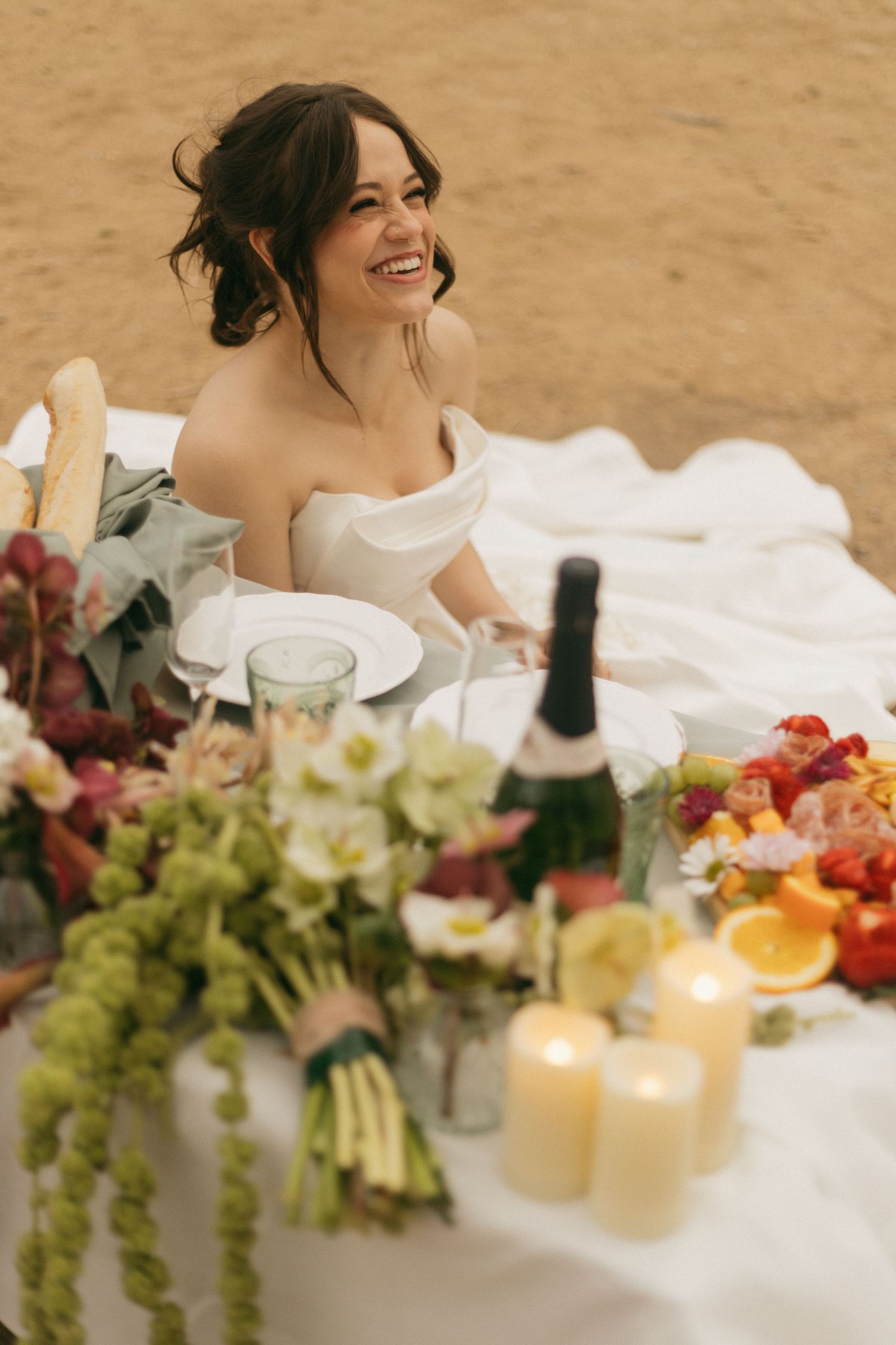 Elegant wedding reception table decorated with fresh flowers, candles and colorful fruits.