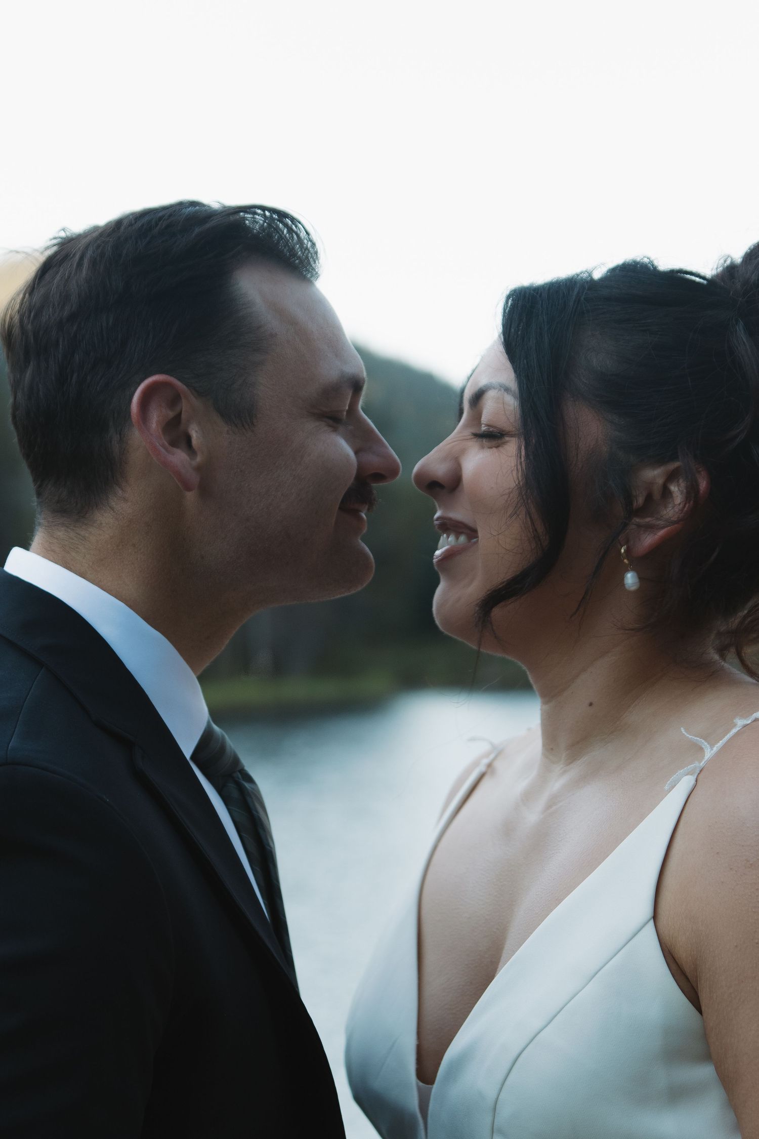 An intimate wedding portrait sequence captures tender moments beside a mountain lake.
