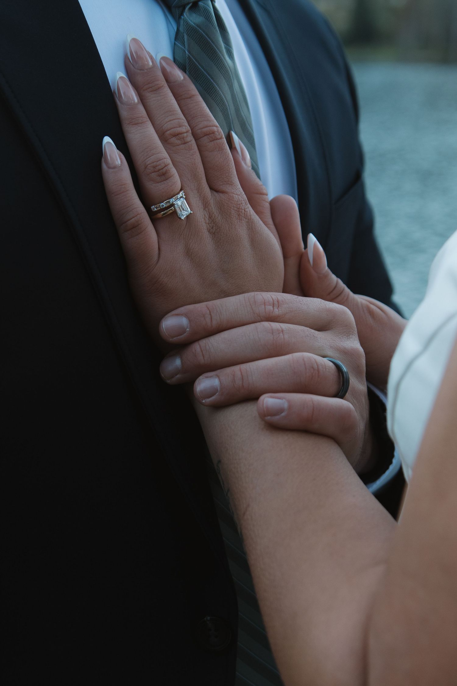Close-up of hands with wedding rings touching during an intimate moment.