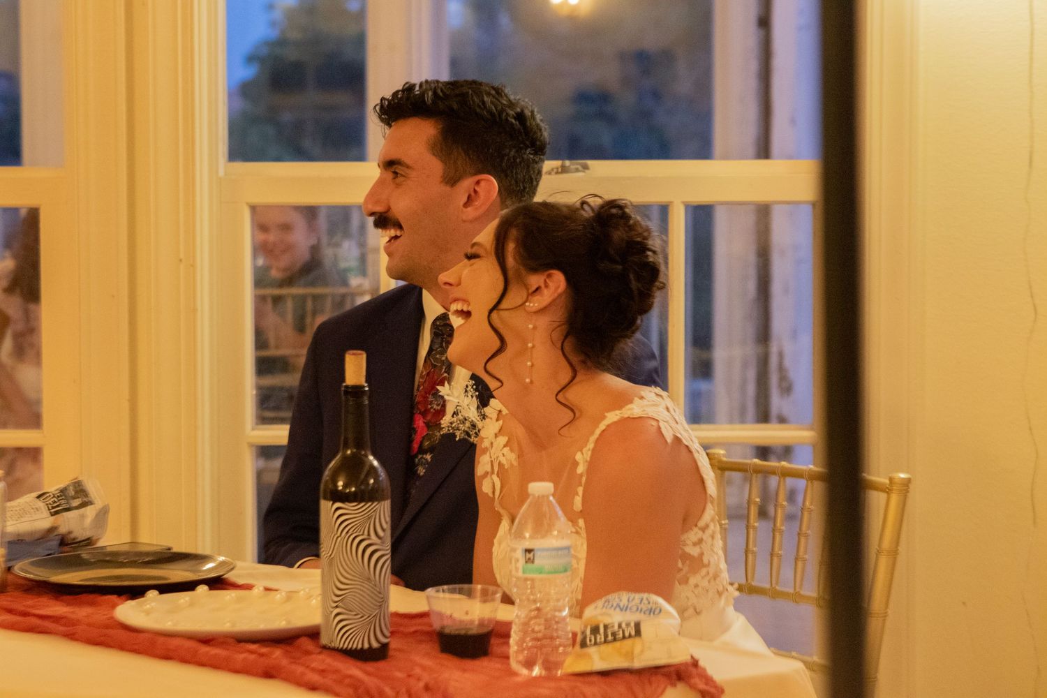 Intimate indoor reception setting with warm lighting and guests seated at tables.