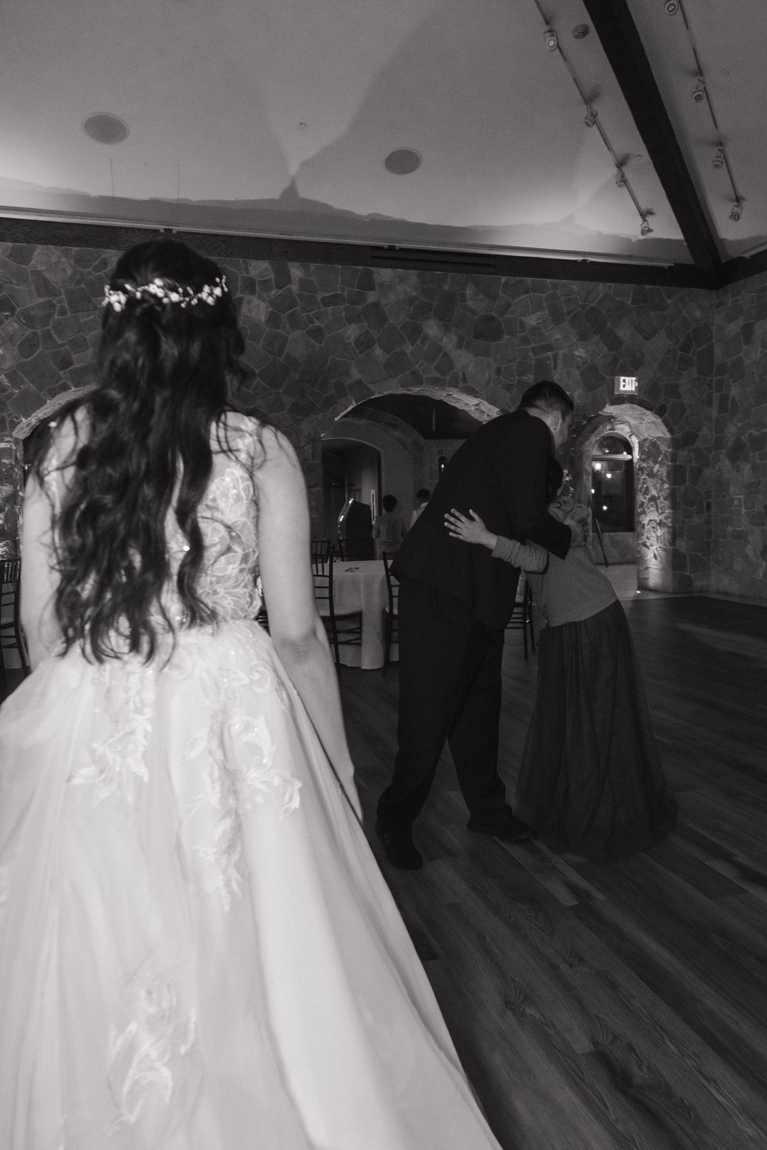 Black and white photo of bride and groom sharing a dance at their wedding reception.