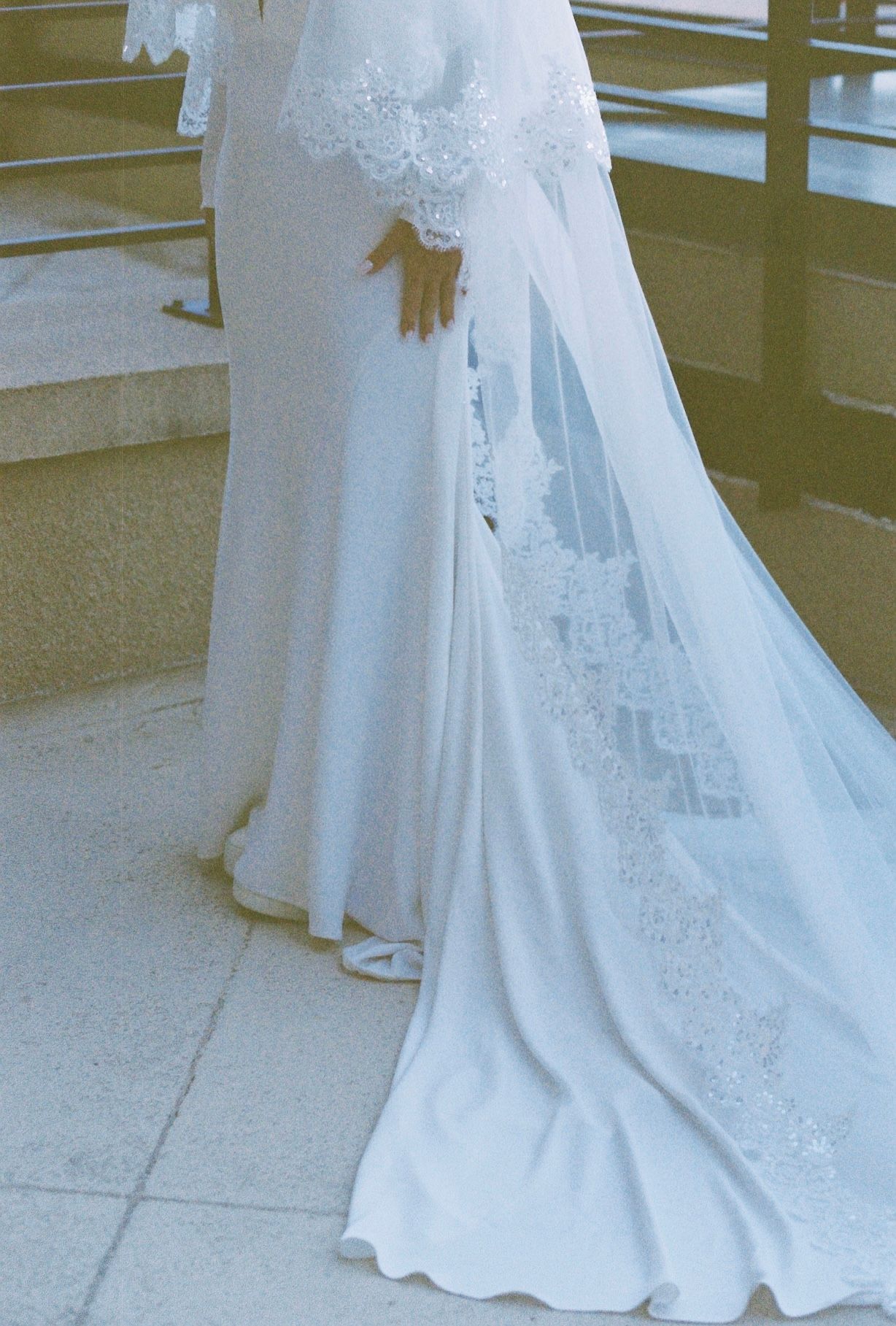 Close-up view of an elegant white wedding dress train with delicate lace details.