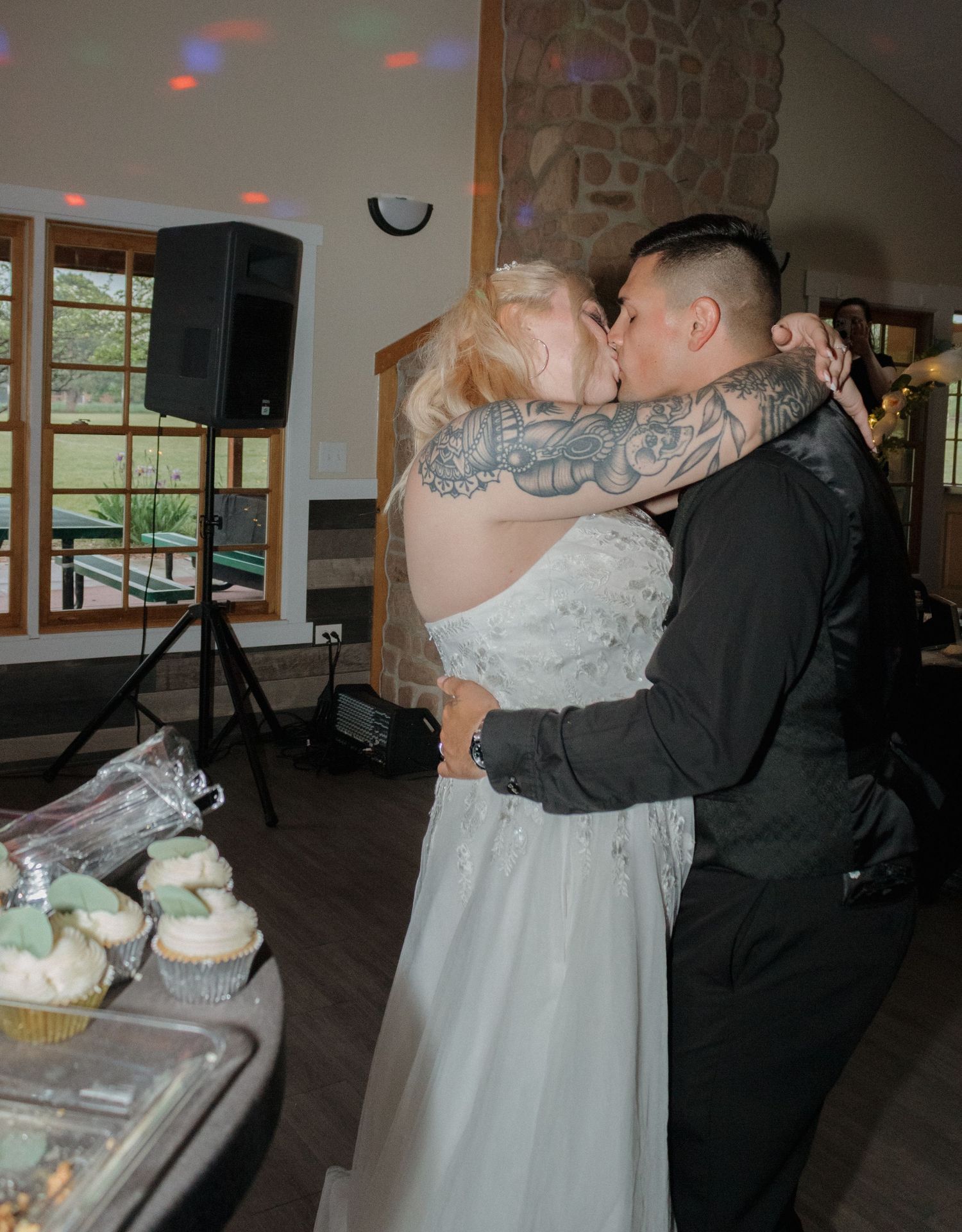 Romantic dance moment at wedding reception with stone fireplace and disco lights.