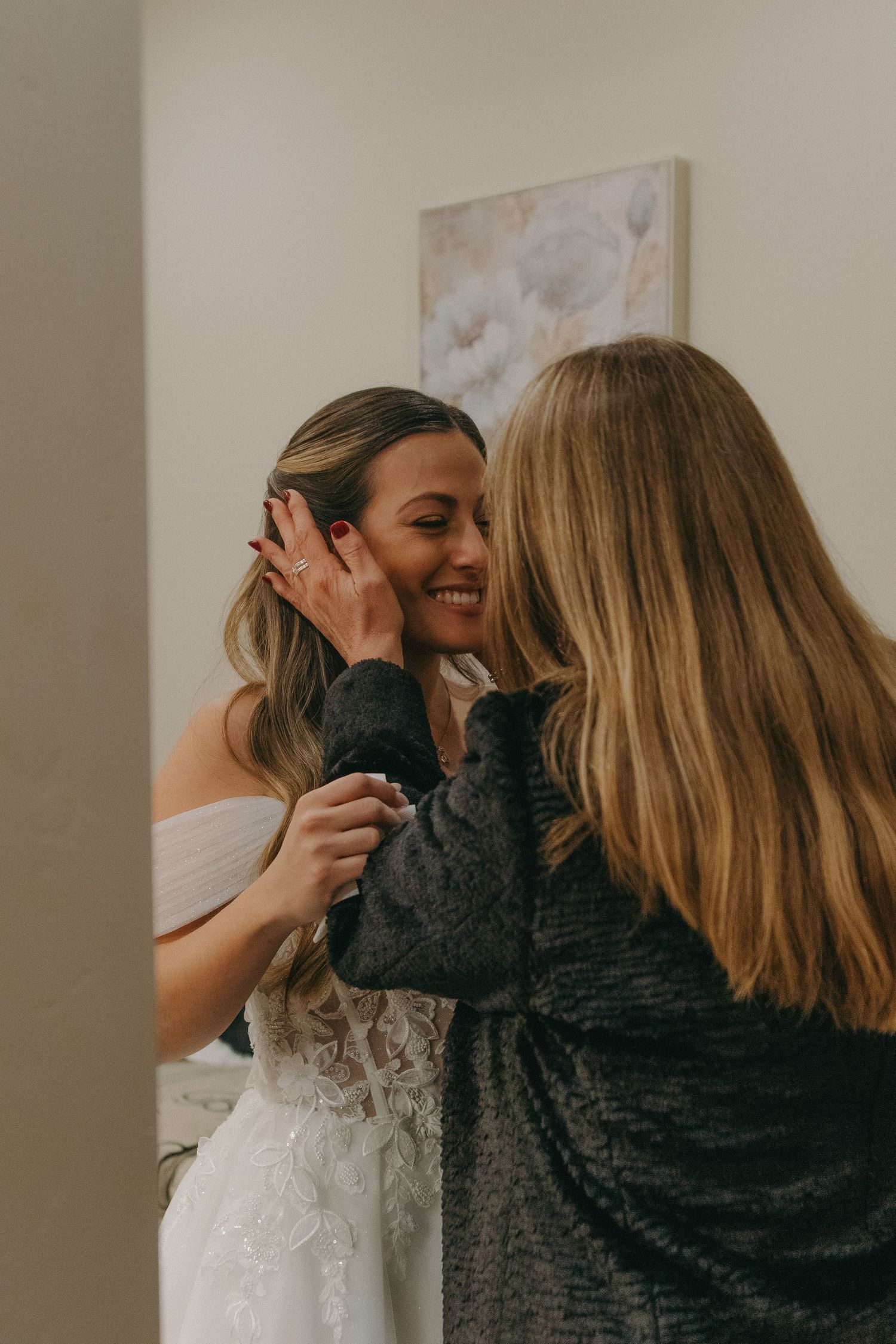 Joyful wedding preparation moments shared between friends in a bright indoor space.