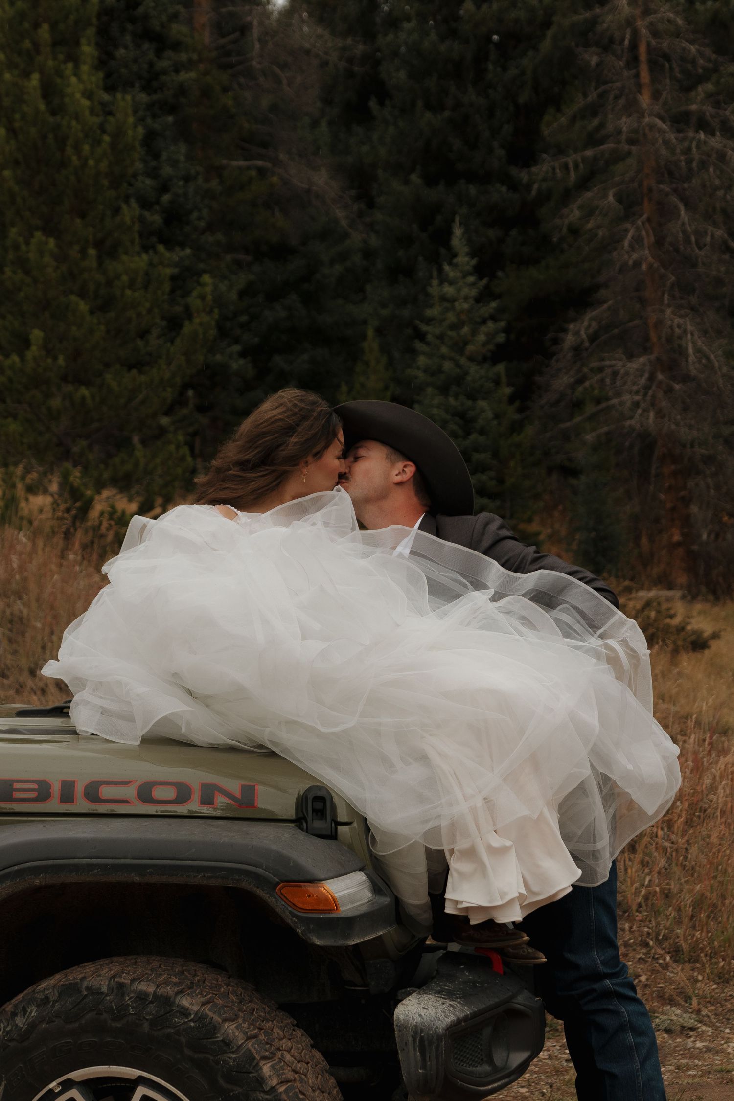 Romantic wedding photos near a GMC truck showcase playful moments between newlyweds.