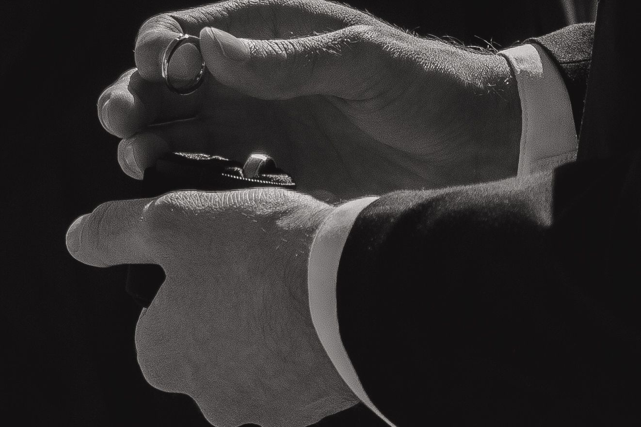 Black and white close-up of hands in an intimate gesture.