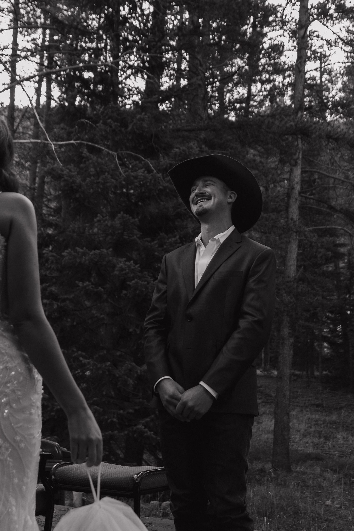 A sequence of four black and white photos showing someone in formal attire outdoors in a wooded setting.