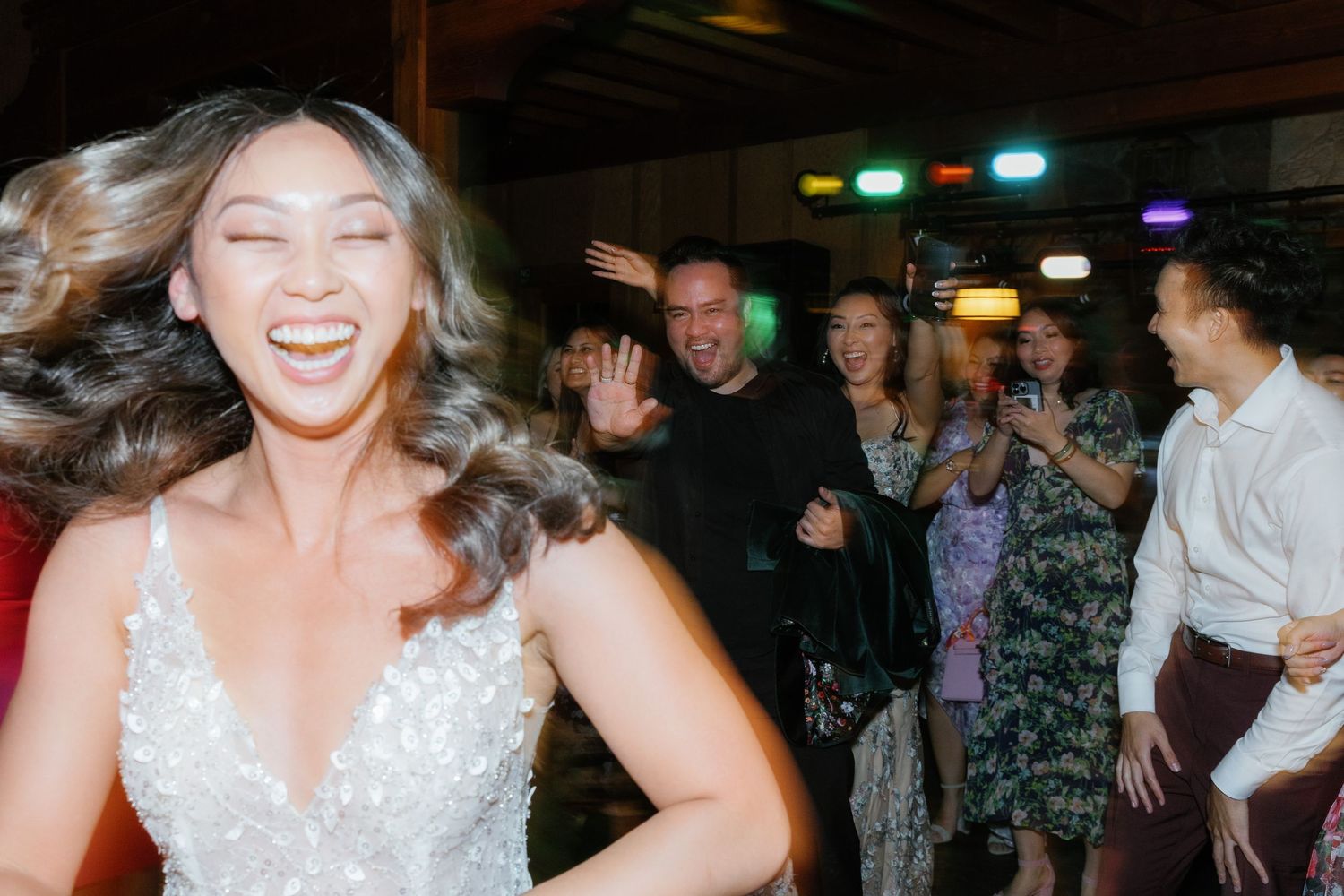 A group of people celebrate and dance together at a lively indoor party or event.