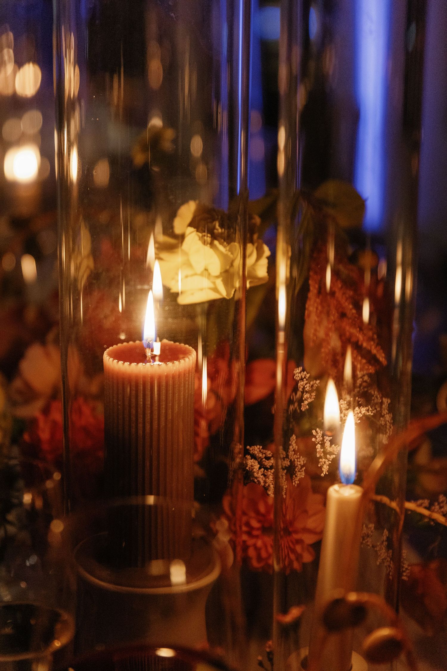 Candlelit table setting with glowing glass hurricanes creating an intimate atmosphere.