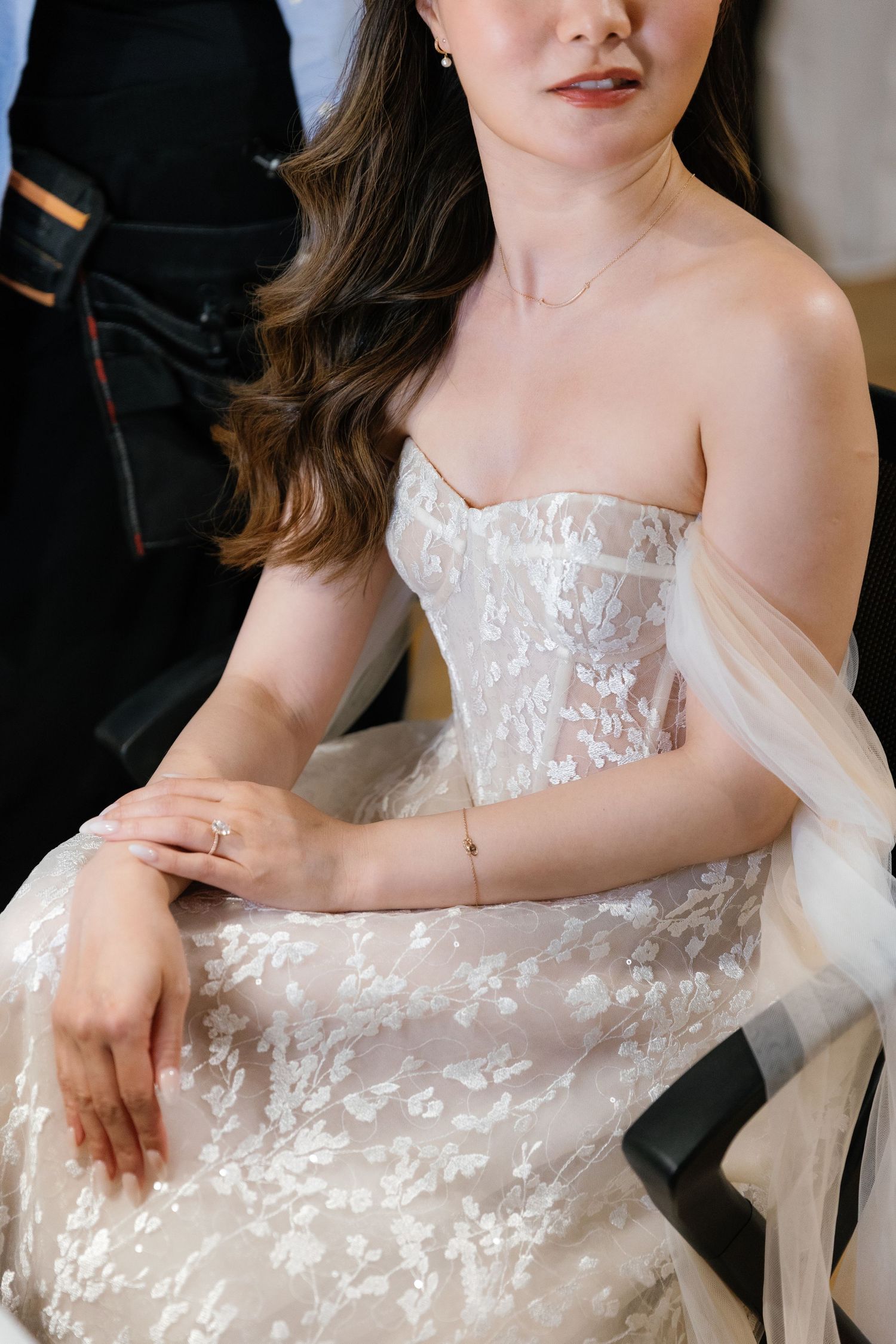 Detail shot of delicate white lace and tulle wedding dress fabric with floral patterns.