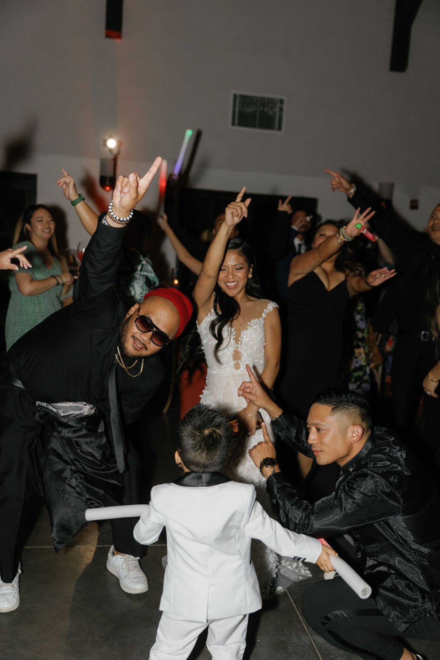 People dancing and celebrating at a party with energetic movements in a dark room.