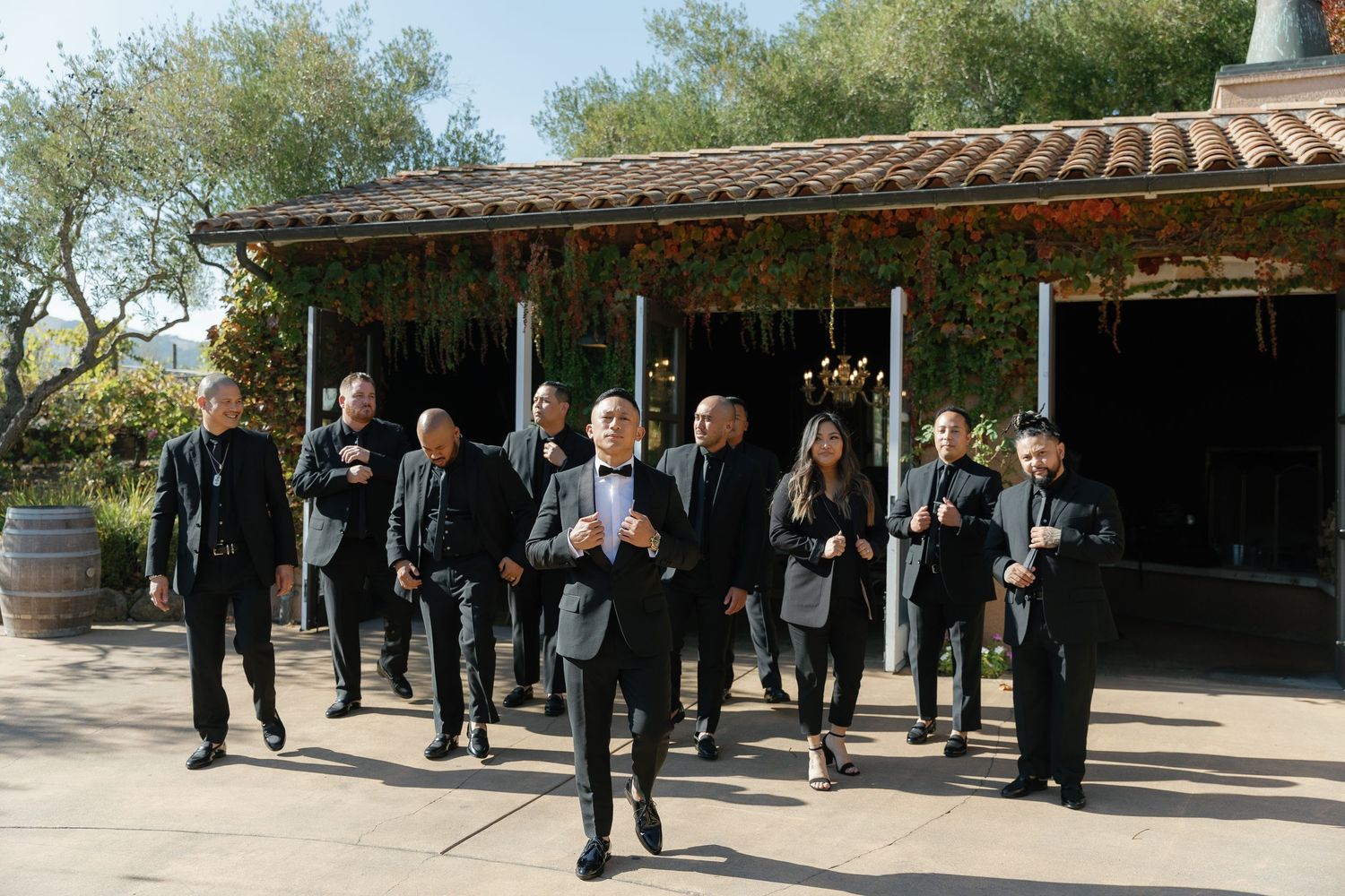 A group of people gathered under a covered walkway at an outdoor venue during a daytime event.